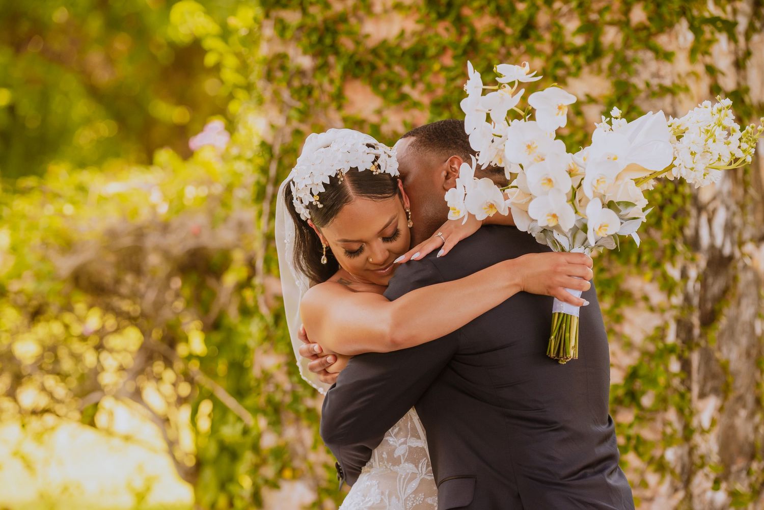 Newlyweds embracing during emotional first look moment in outdoor garden.