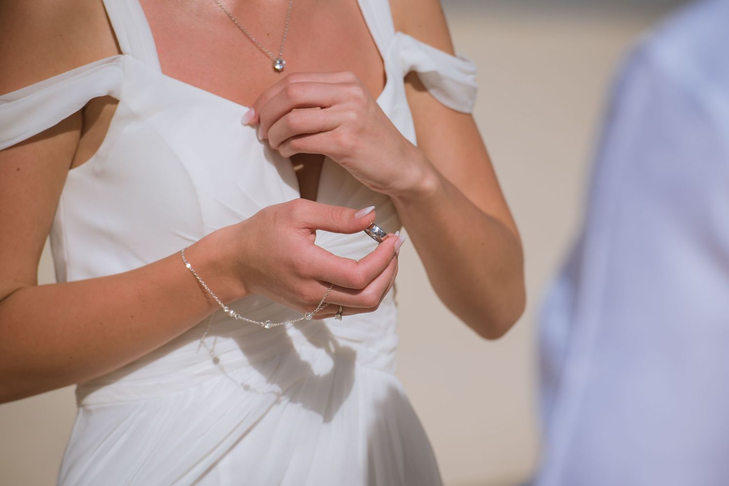 Close-up details of wedding ceremony interactions on a sunny beach day.