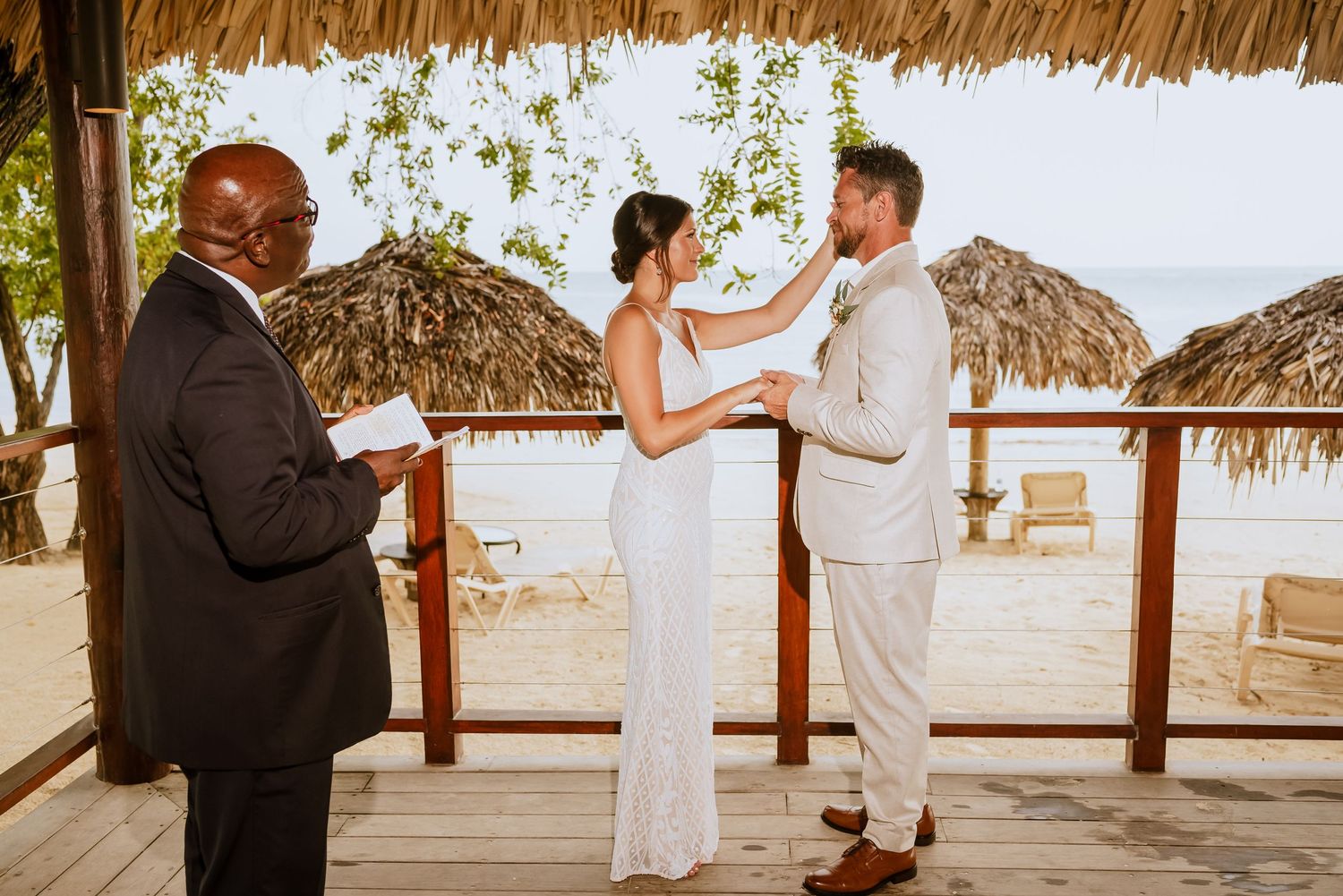 Beachside wedding ceremony sequence under palm trees and thatched roof structures.