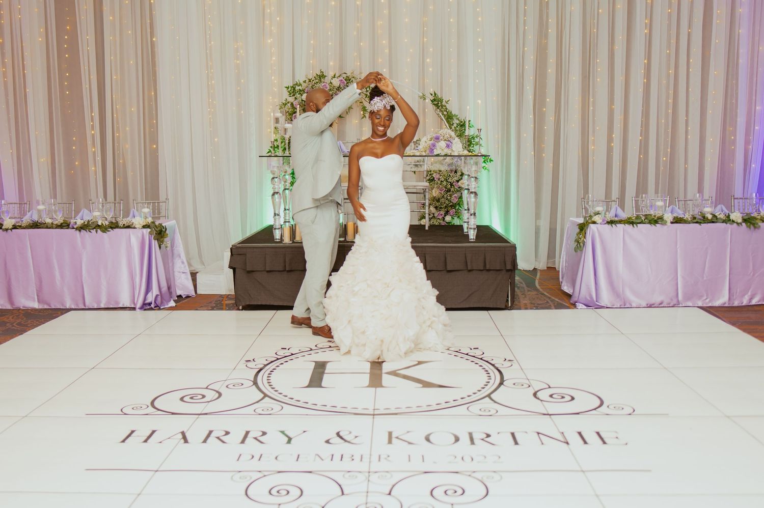 Custom monogram dance floor design with elegant white and purple lighting effects.
