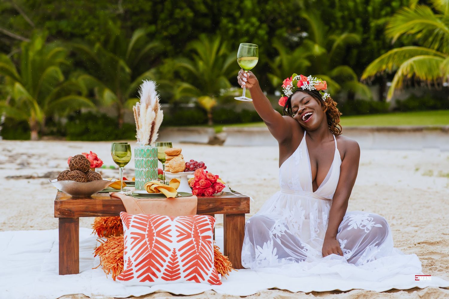 Beachside picnic setup with orange and white decor on wooden furniture.