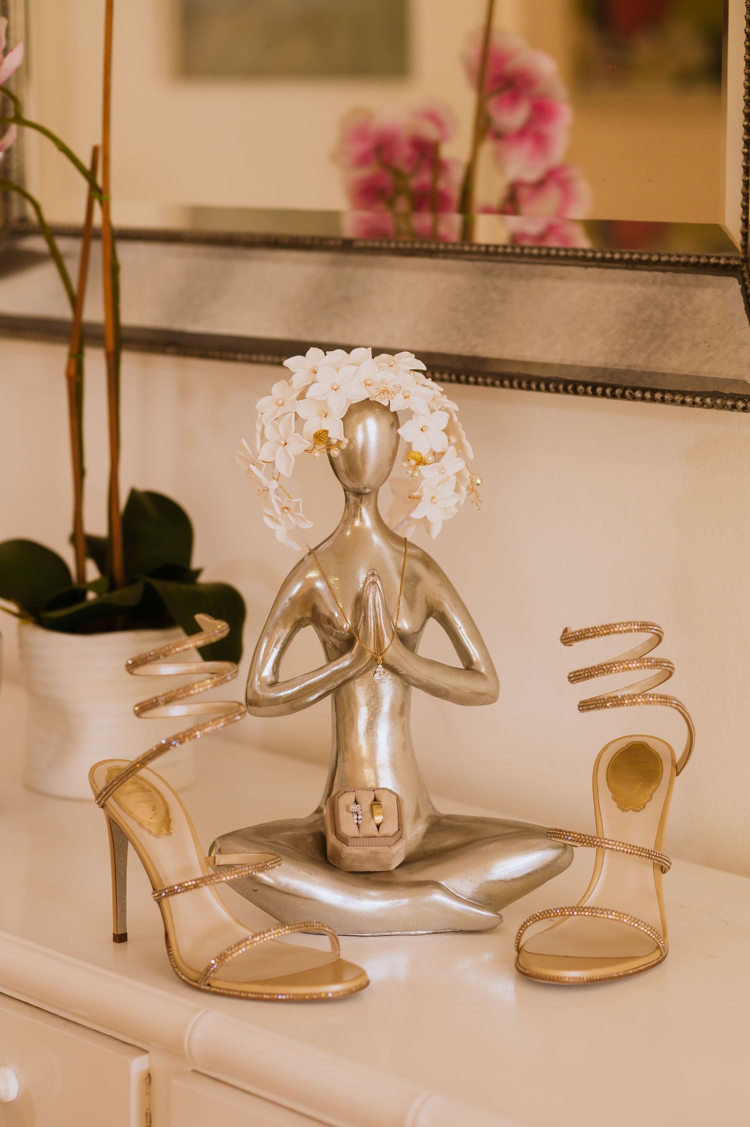 Elegant gold and silver wedding shoes displayed with delicate orchid flowers.