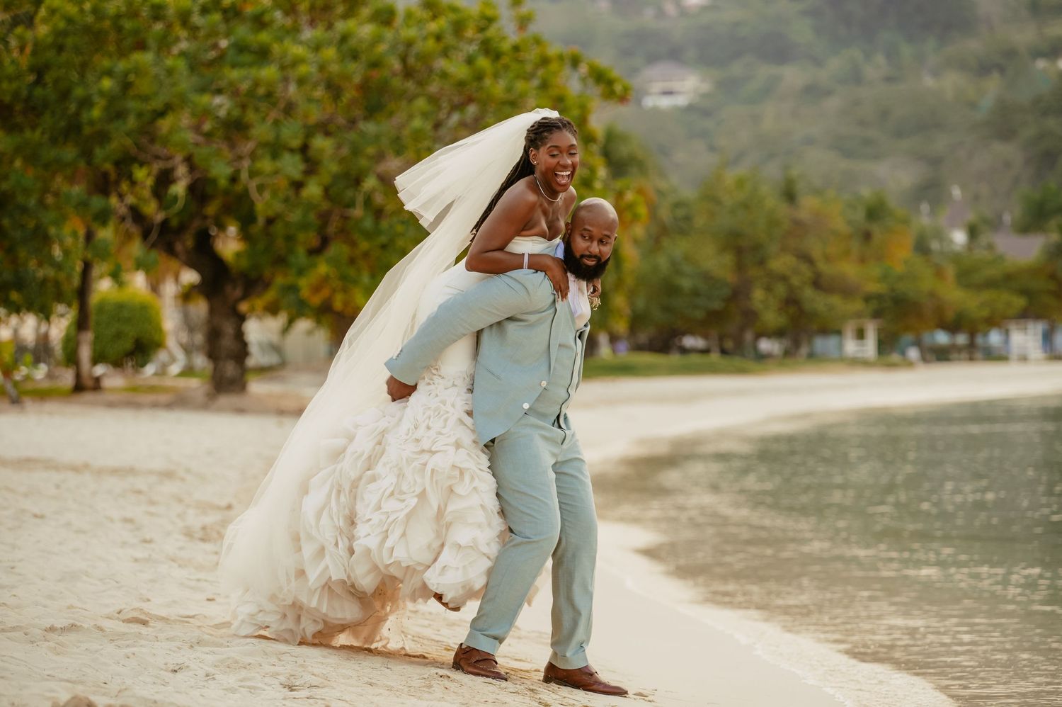 A romantic beach wedding photo session with a flowing white dress and mint suit against a scenic waterfront backdrop.