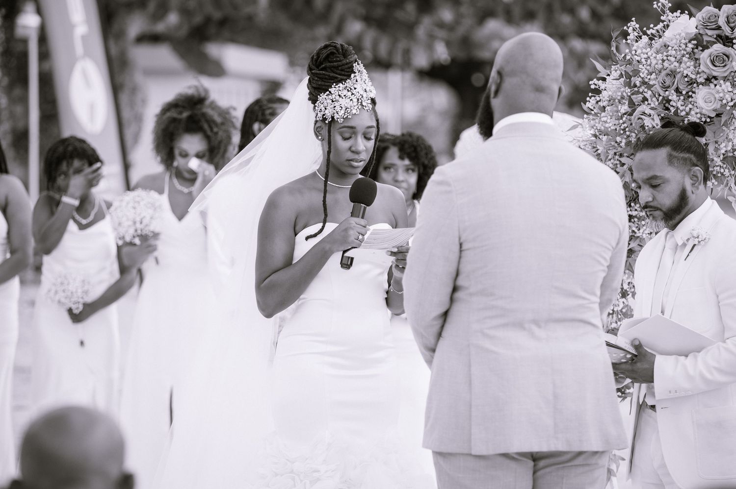 Black and white photo of wedding guests celebrating during an outdoor ceremony.