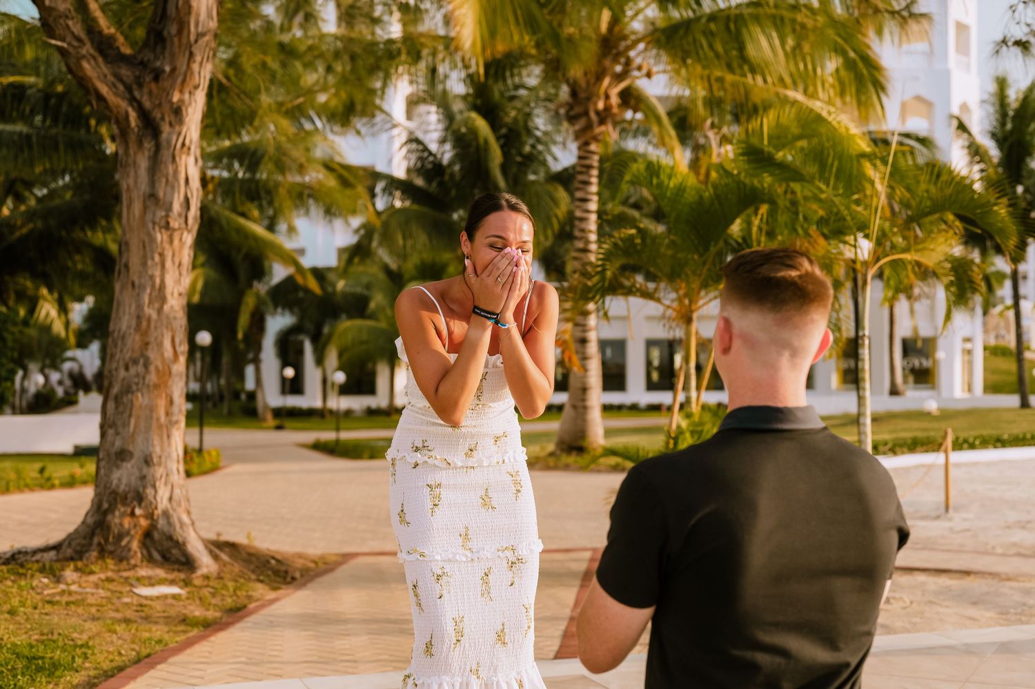 Romantic outdoor photoshoot with palm trees and natural lighting at sunset.