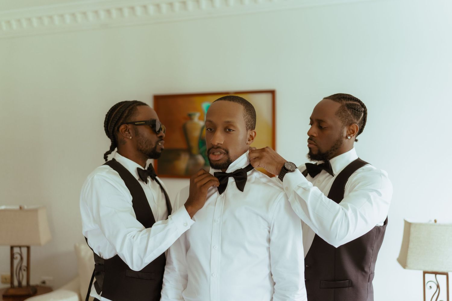 Groomsmen in white formal attire sharing moments before the ceremony.