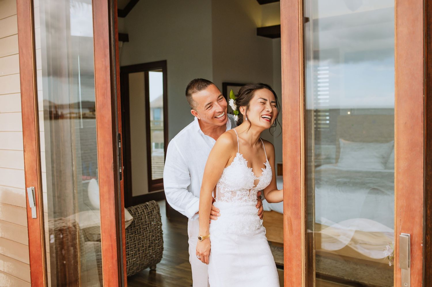 A romantic scene unfolds on a beachfront patio with tropical decor.