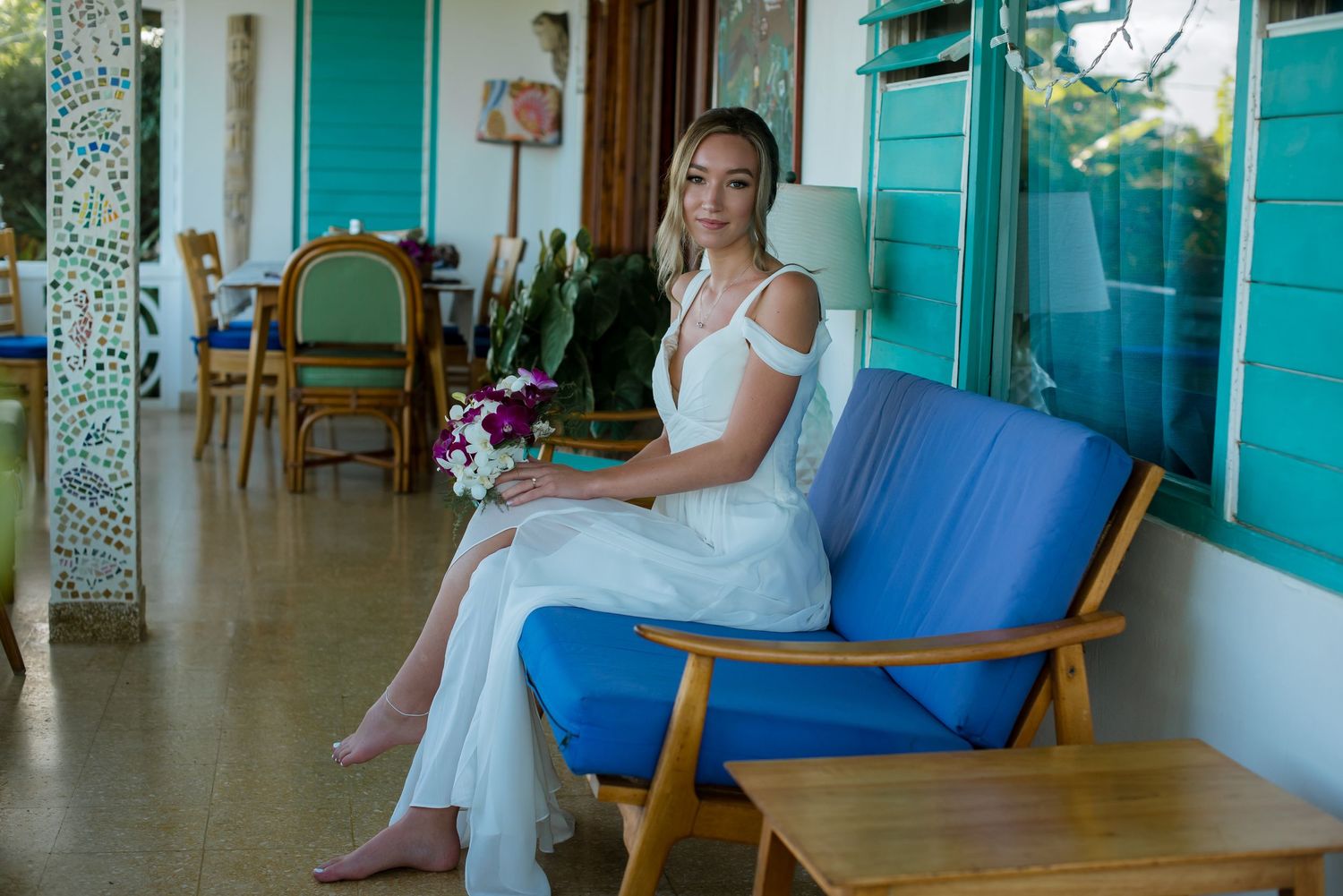 Beachy wedding venue with turquoise walls and wooden furniture.