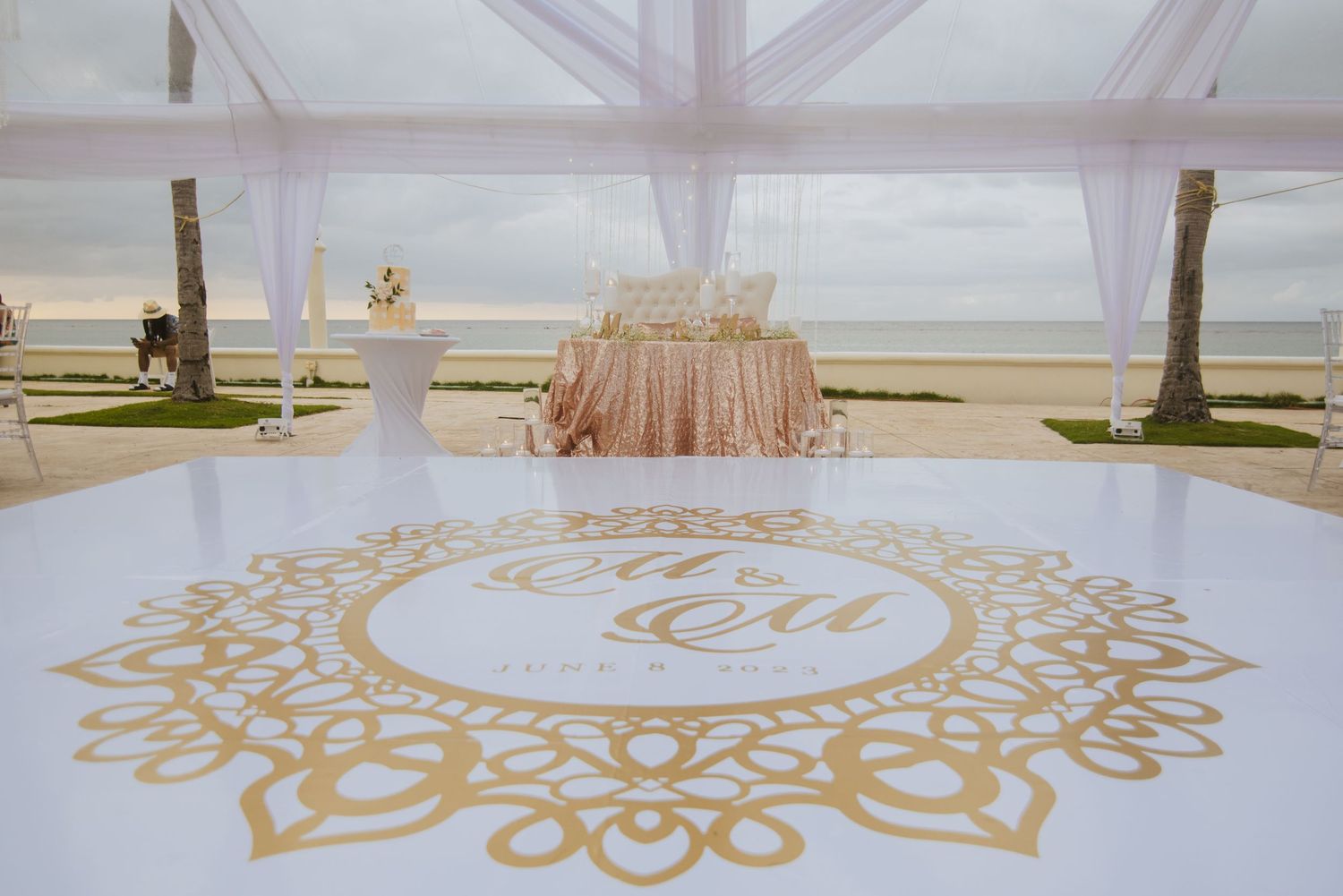 Elegant gold mandala floor decal design in white wedding tent venue.