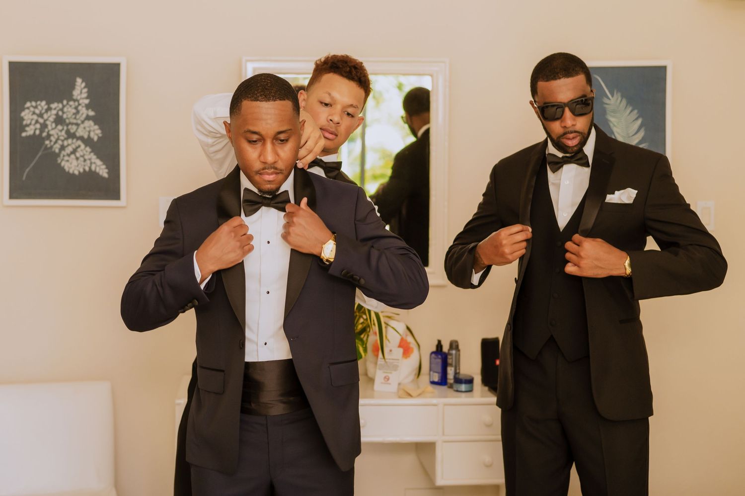 Candid moments of formal preparation with black and white attire against neutral walls.