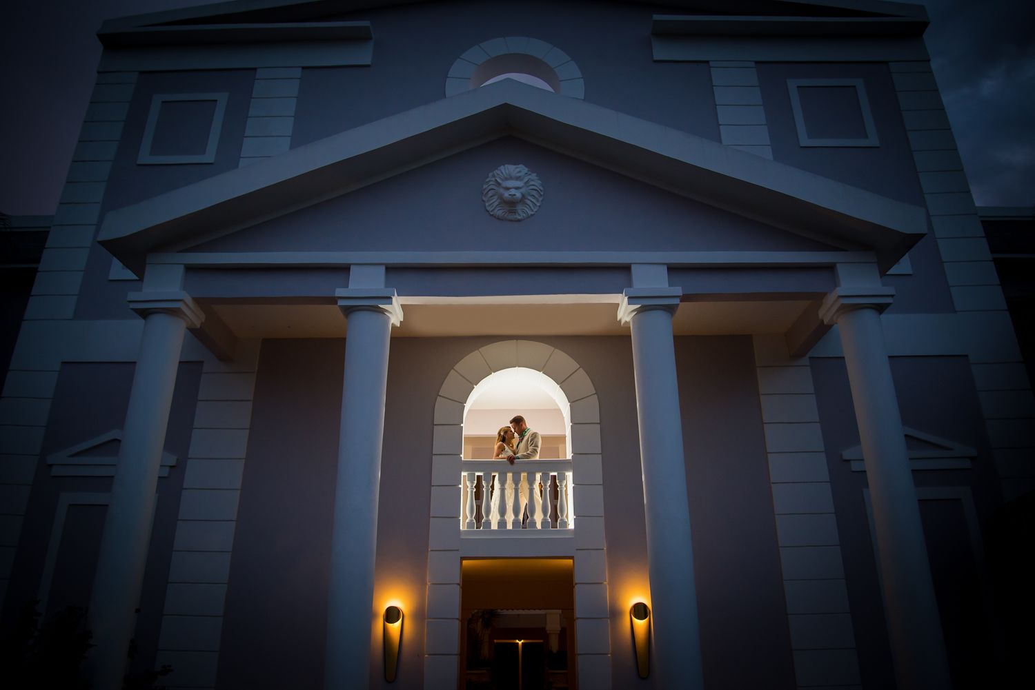Dramatic nighttime architectural shot of chapel entrance with illuminated archway.