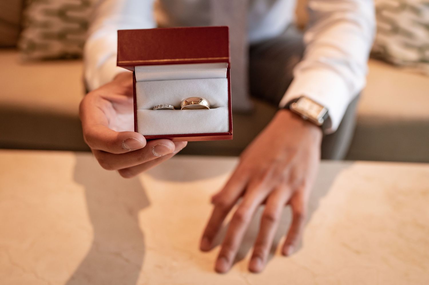 Close-up shots of hands holding wedding accessories and jewelry boxes.