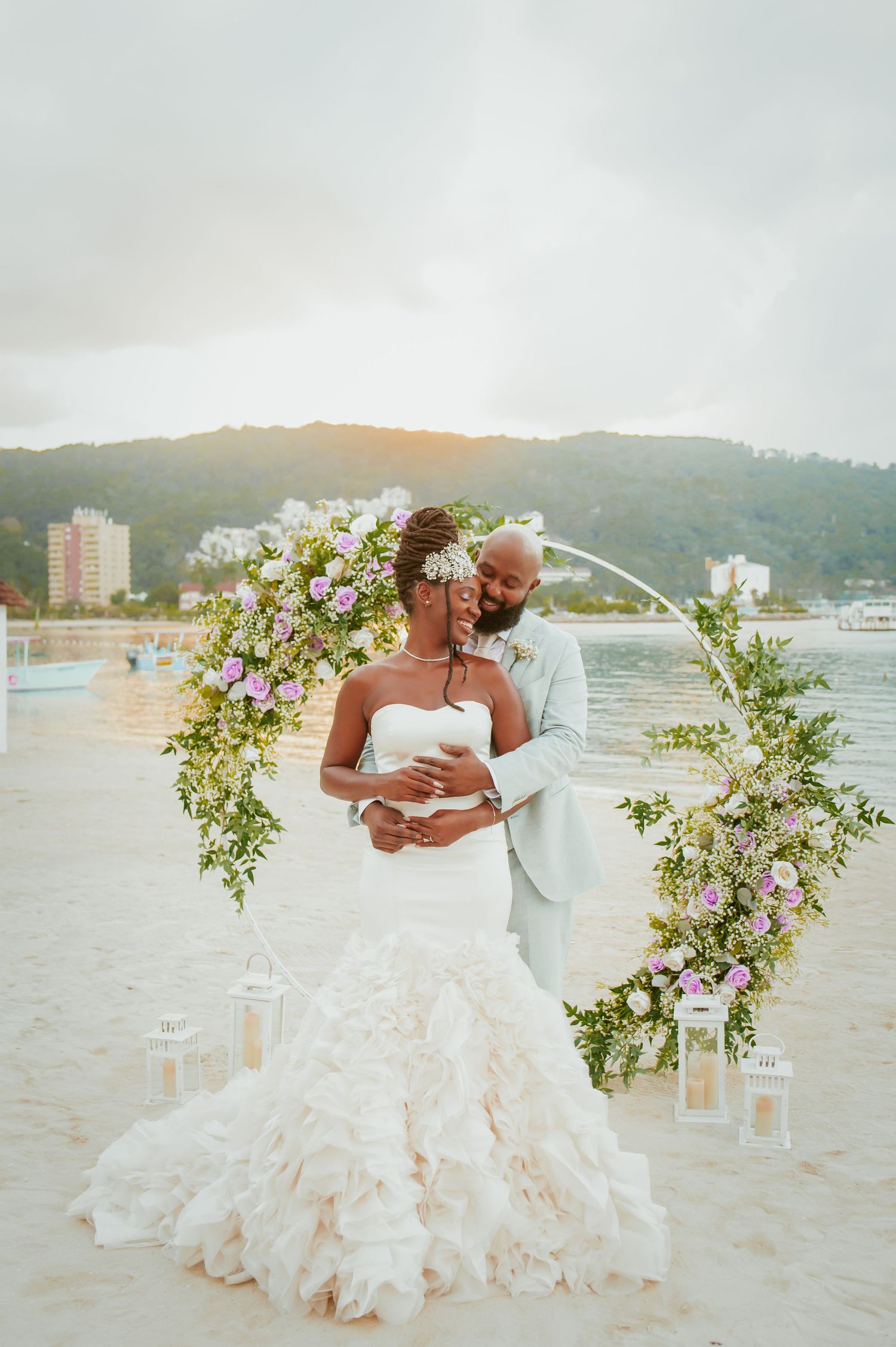 Intimate beach wedding ceremony with floral arch and ocean views.