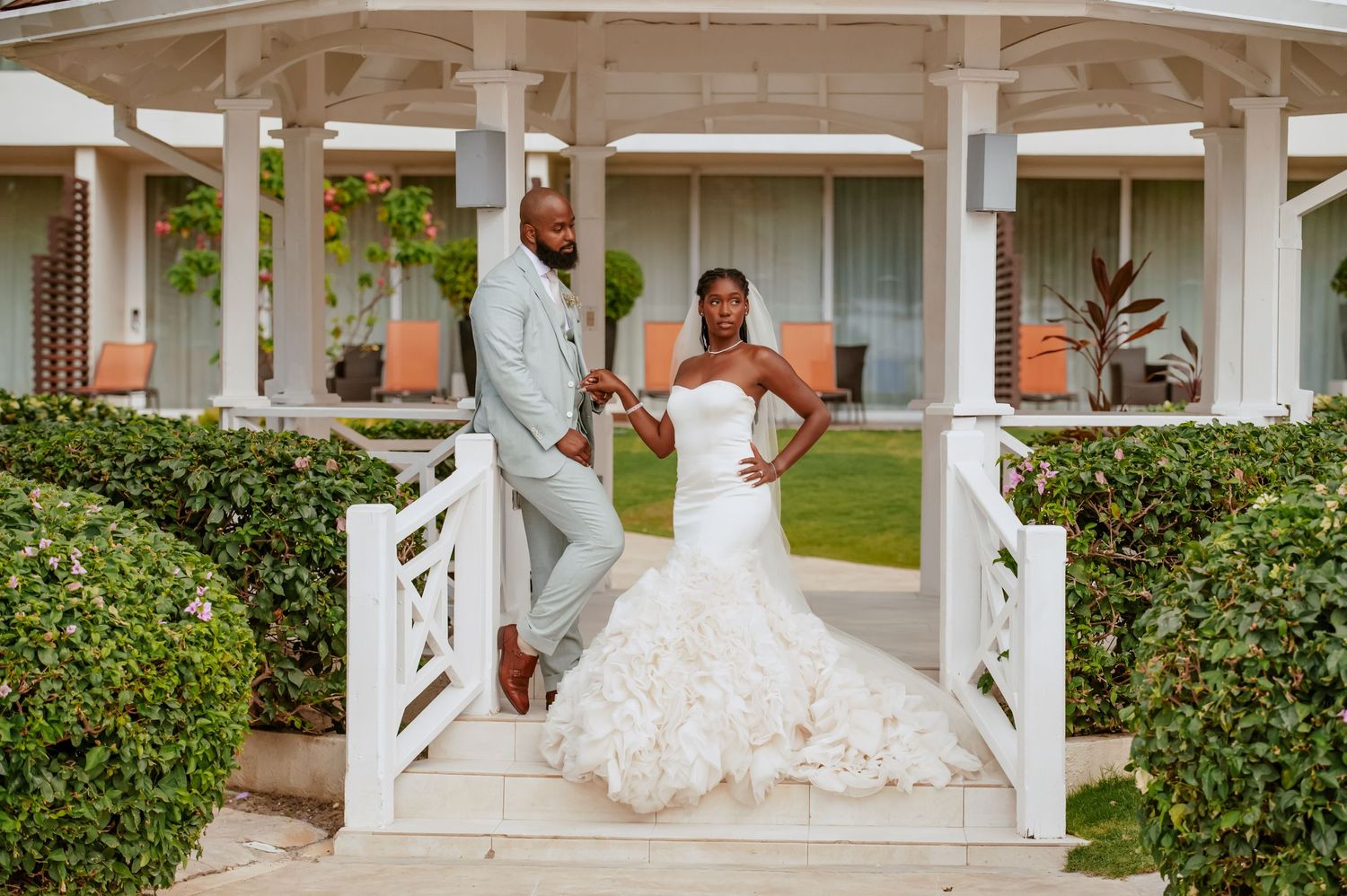 Wedding photos captured at a coastal venue featuring a white gazebo and manicured gardens.