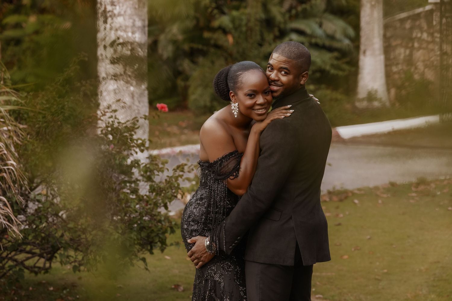 Couple sharing intimate moments in outdoor garden setting.