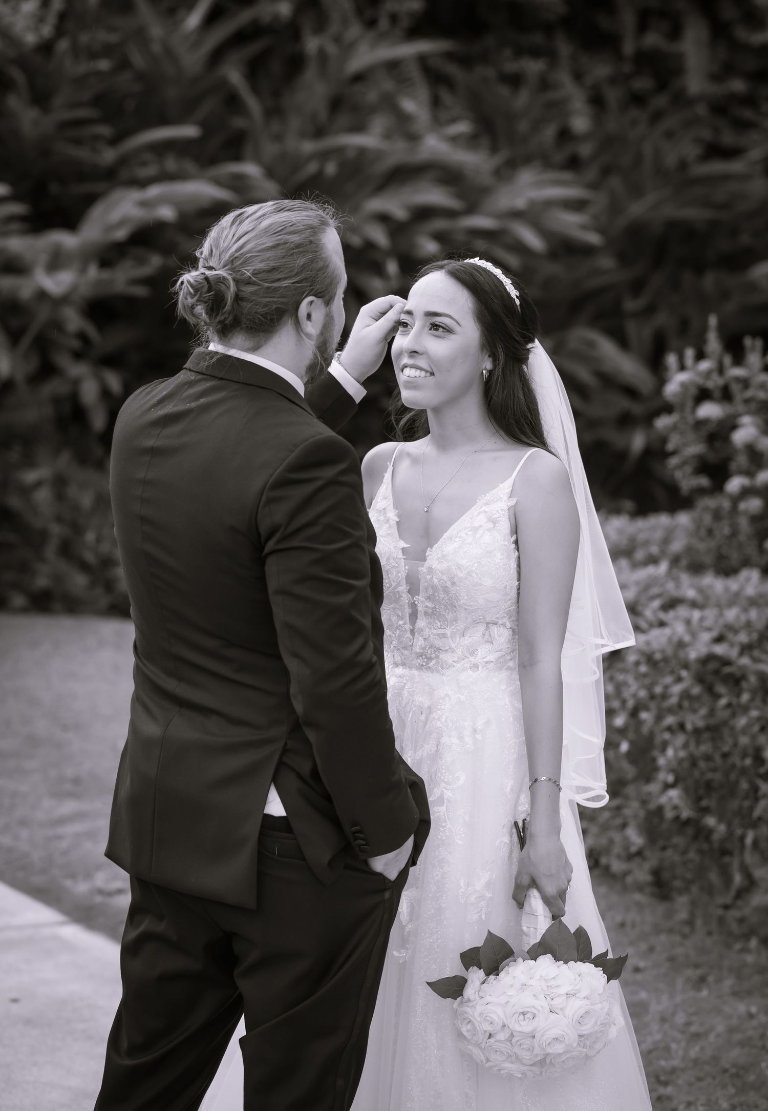 Black and white wedding photos showing romantic moments between newlyweds in an outdoor garden setting.