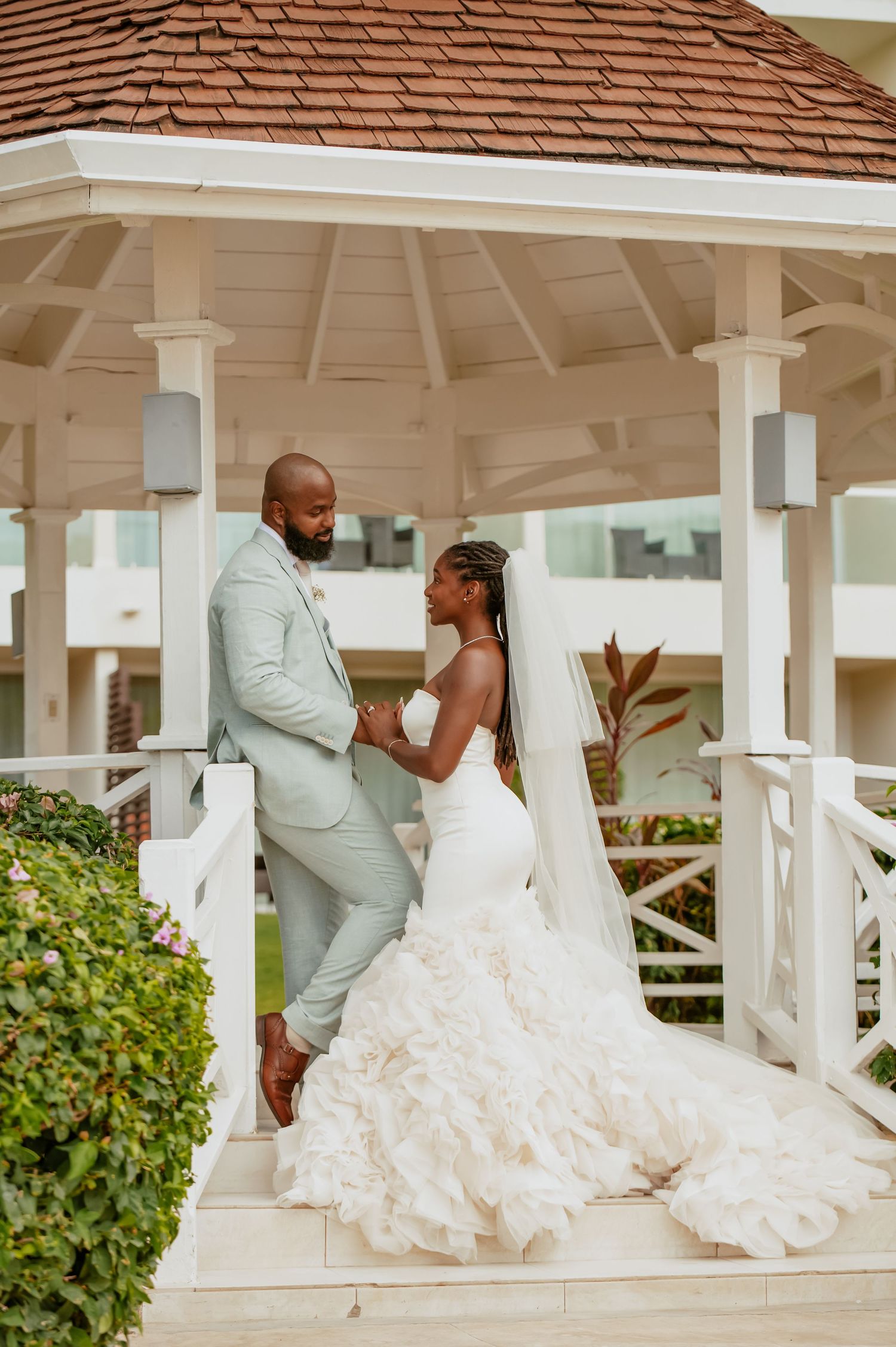 Romantic wedding portraits taken under a white gazebo with elegant architectural details.