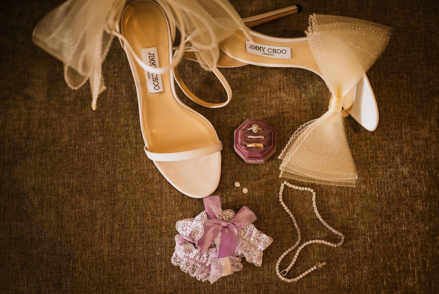 Artistic detail shot of bridal shoes and accessories in warm sepia tones.