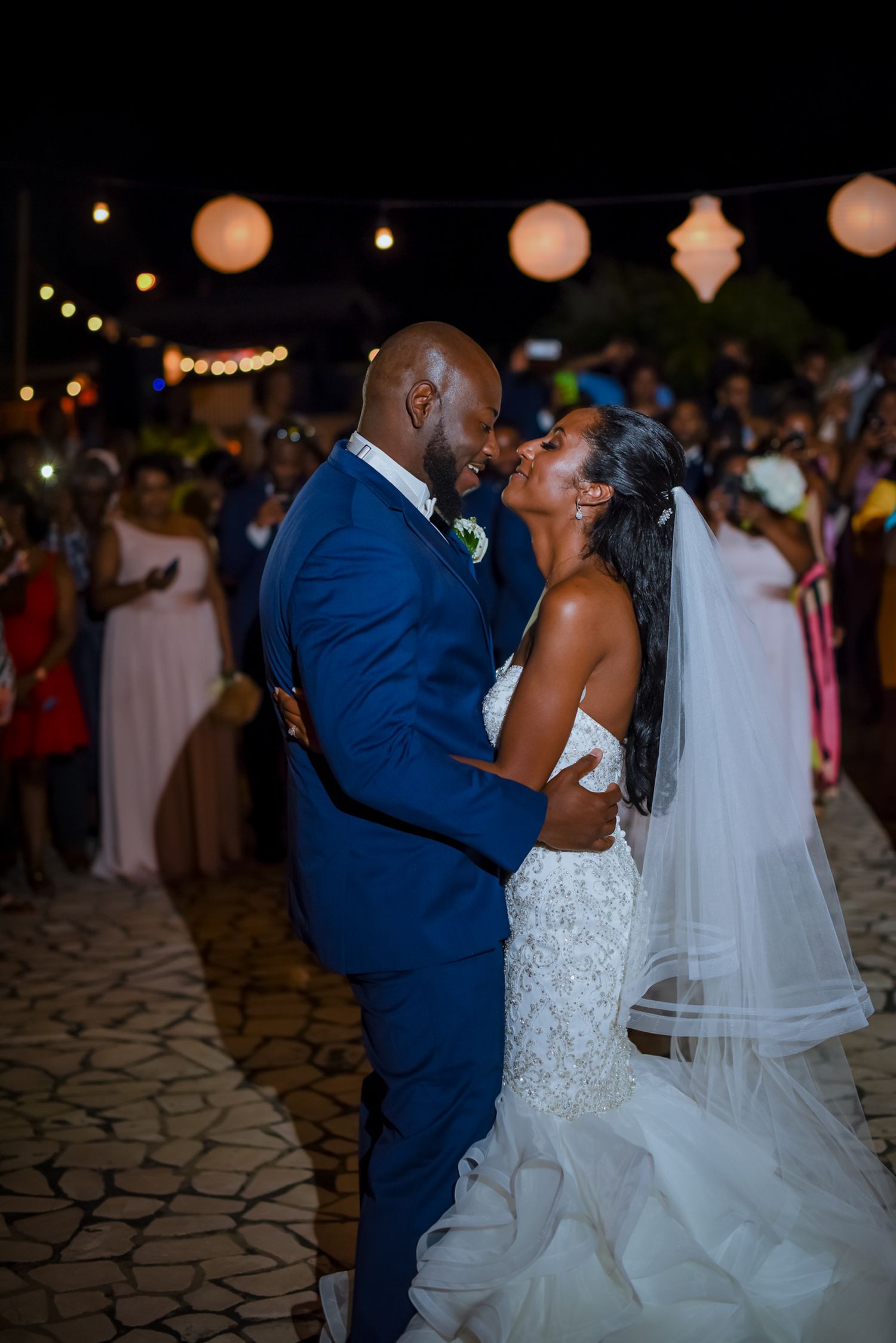 Newlyweds dancing together during their evening outdoor reception.