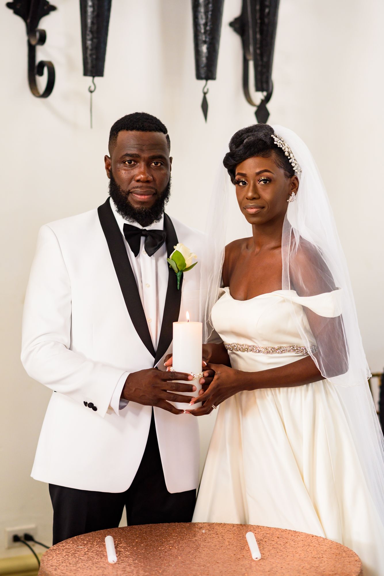 Elegant wedding couple poses for formal portraits in white attire.