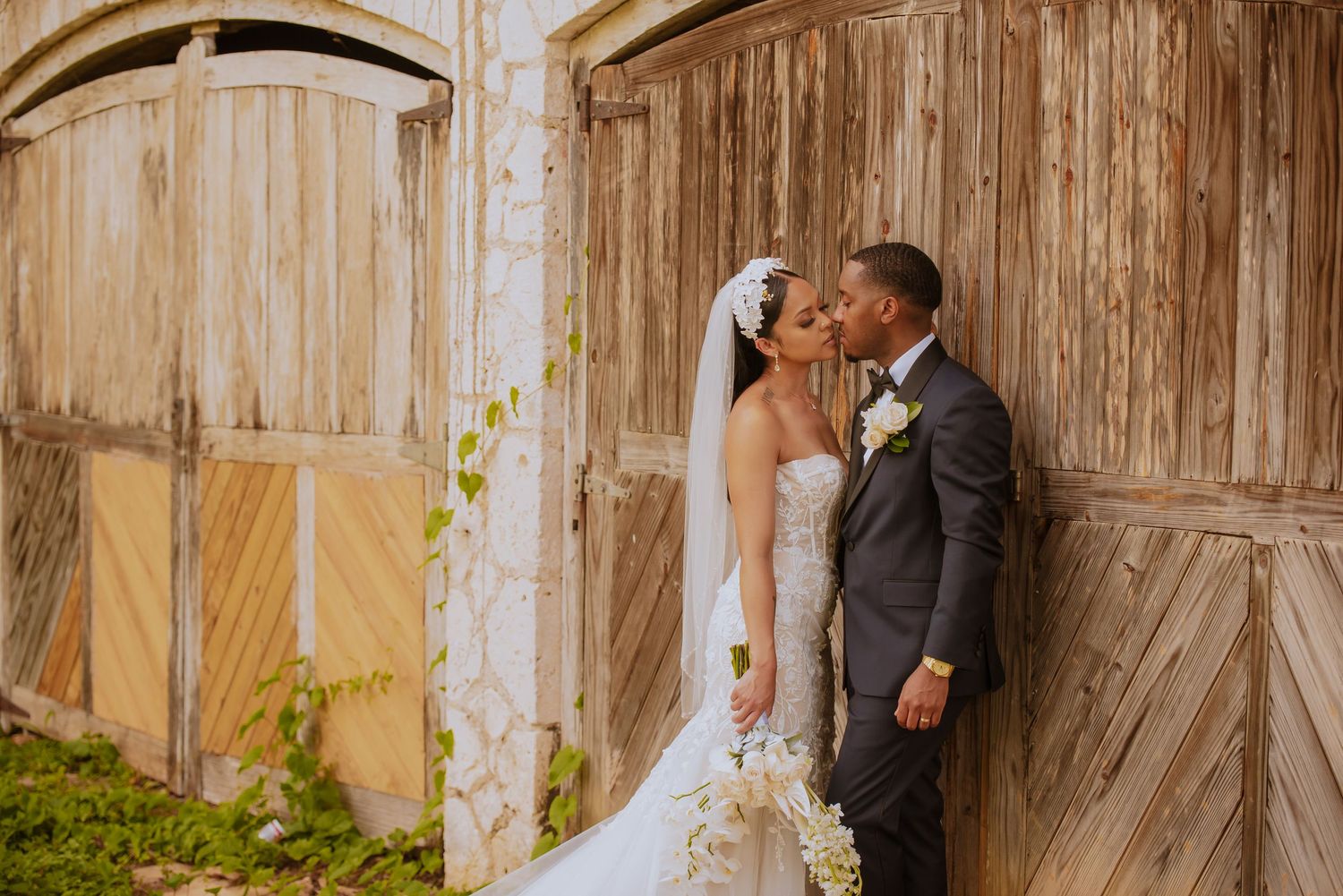 Intimate wedding moment captured against vintage wooden doors and stone architecture.