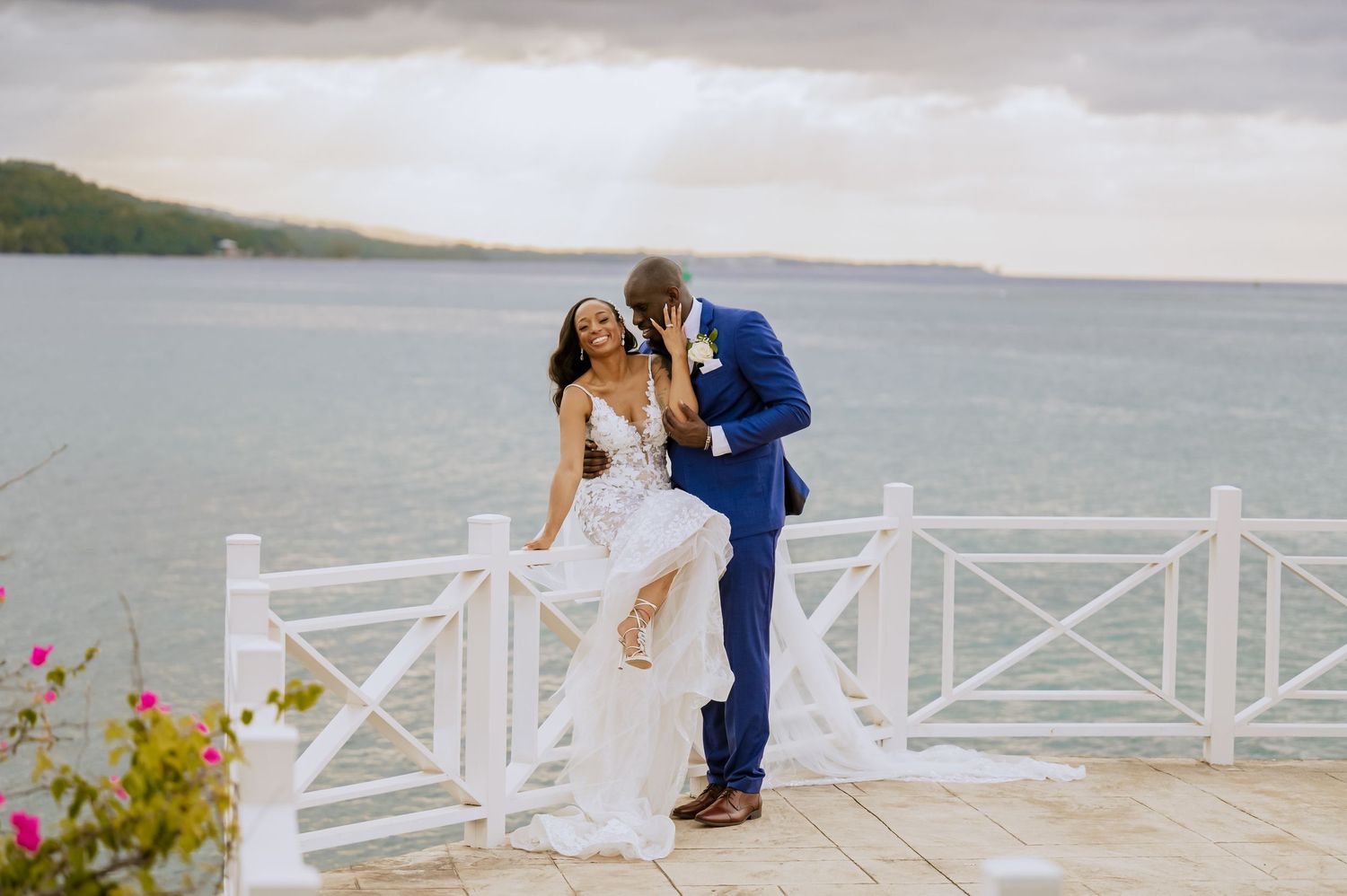 Panoramic wedding photo featuring white deck railings and scenic ocean views.
