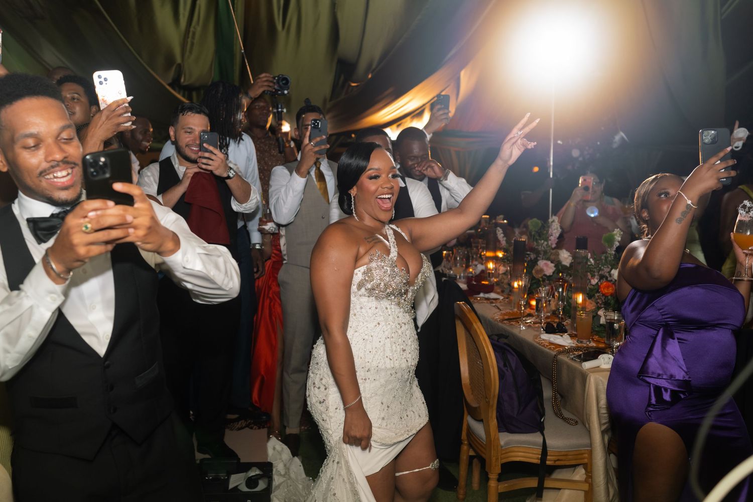 Wedding reception party with guests dancing and celebrating under evening lighting.