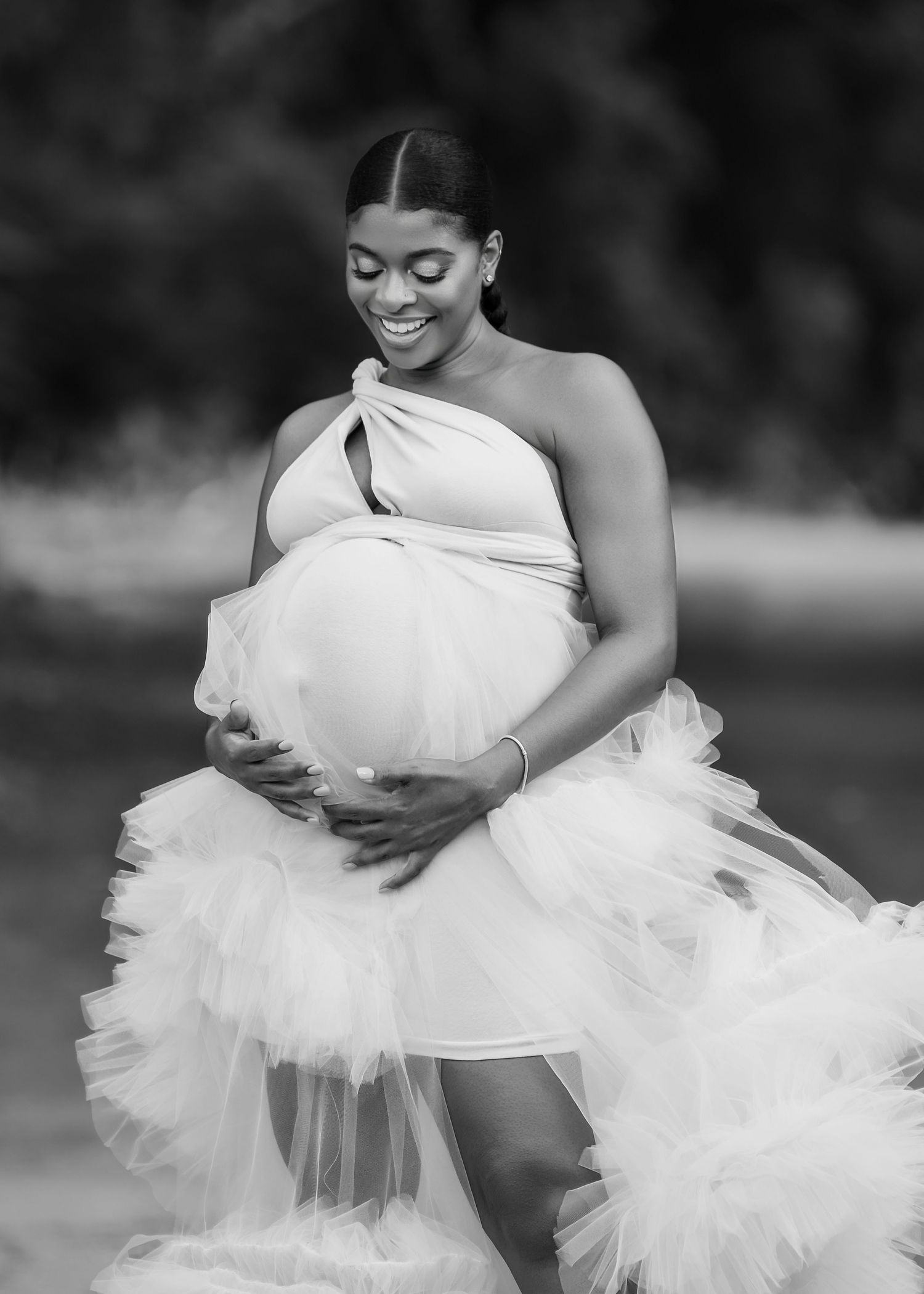 Elegant maternity portrait in black and white featuring flowing tulle gown.