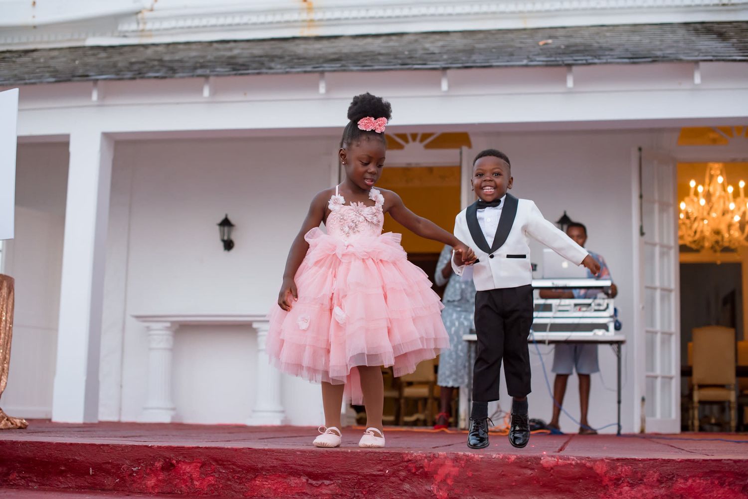 Wedding celebration in a white venue with guests enjoying the festivities.