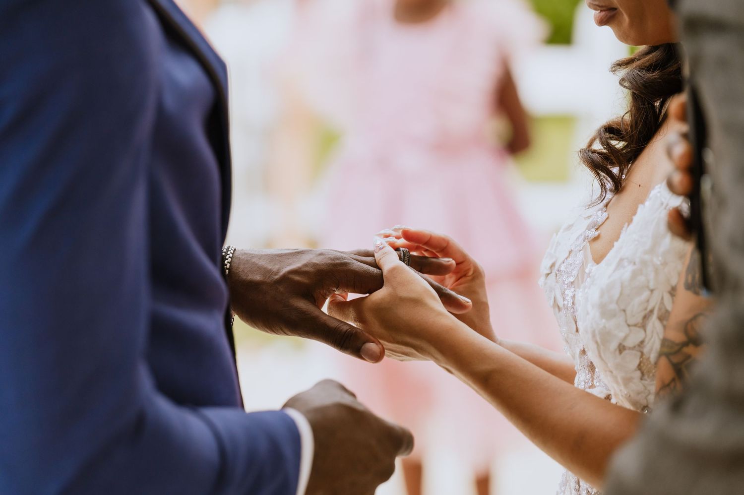 Intimate moment of exchanging wedding rings between couple's hands.