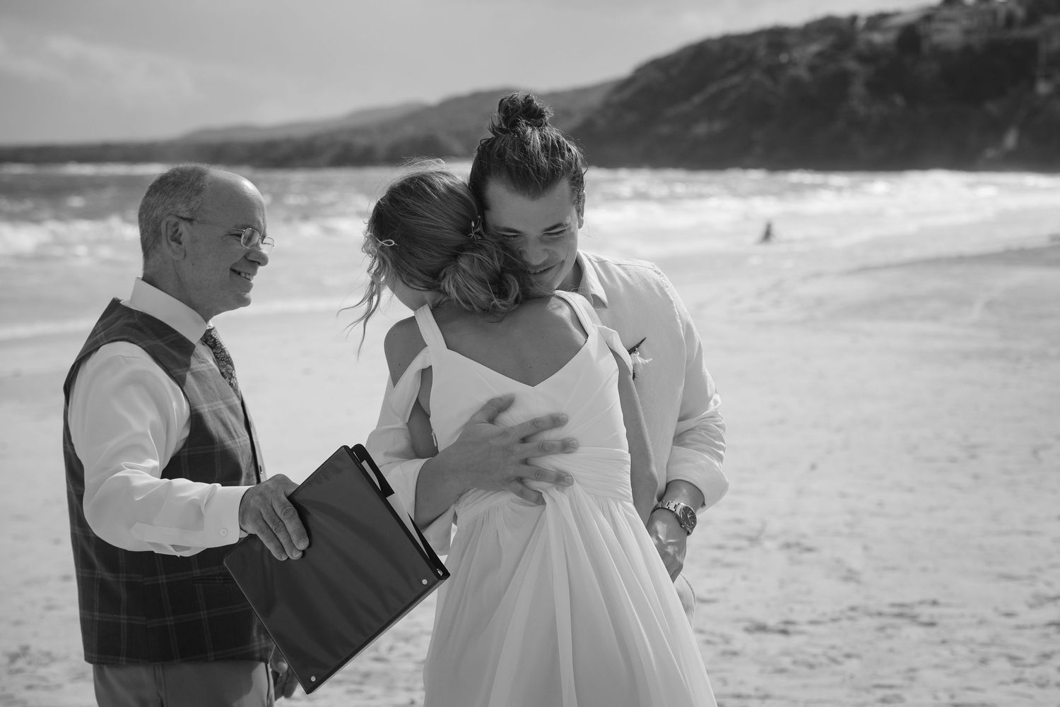 Black and white photo of wedding ceremony moments on a scenic beach.