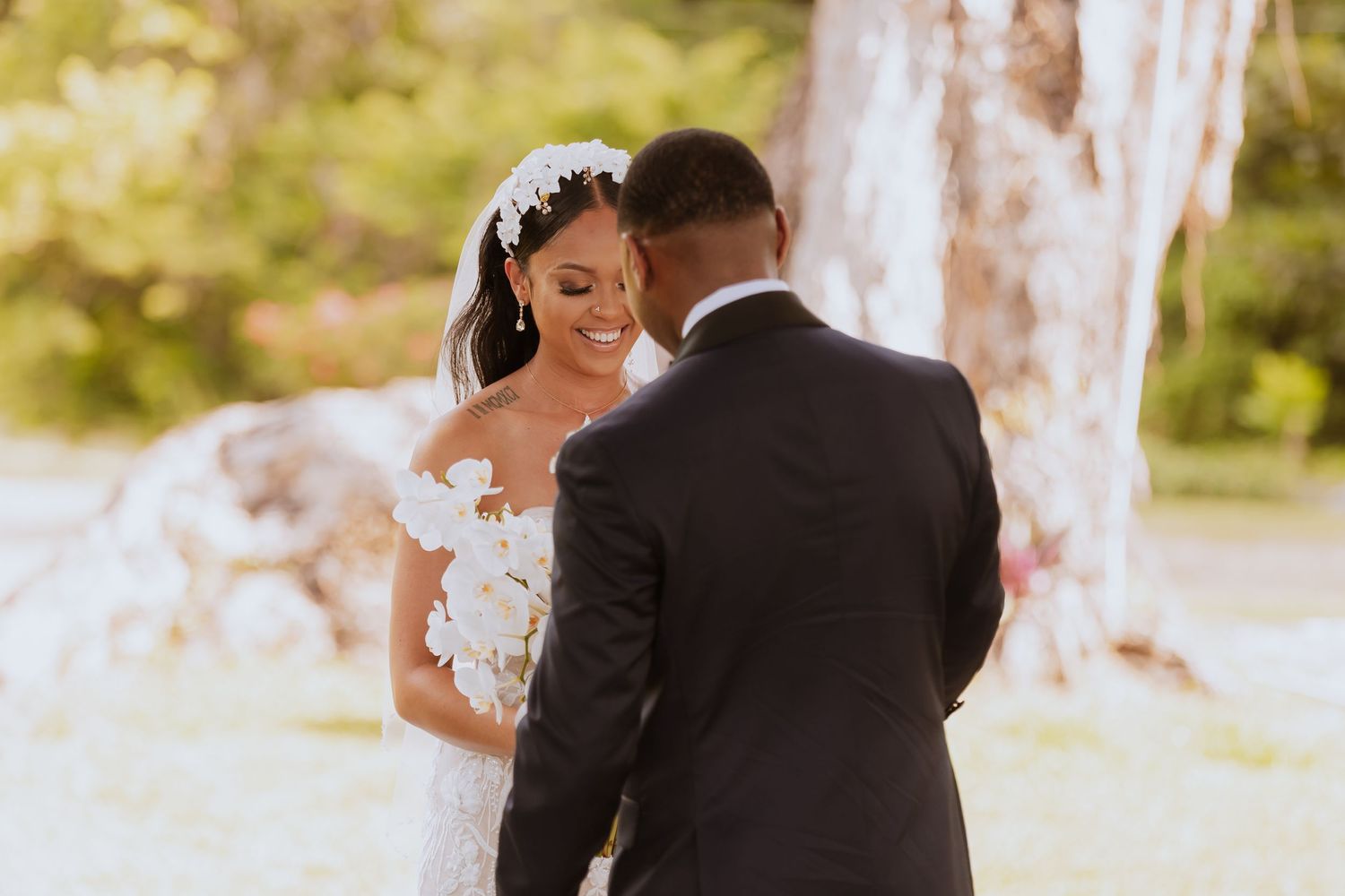 Bride and groom sharing emotional first look moment in golden sunlight.
