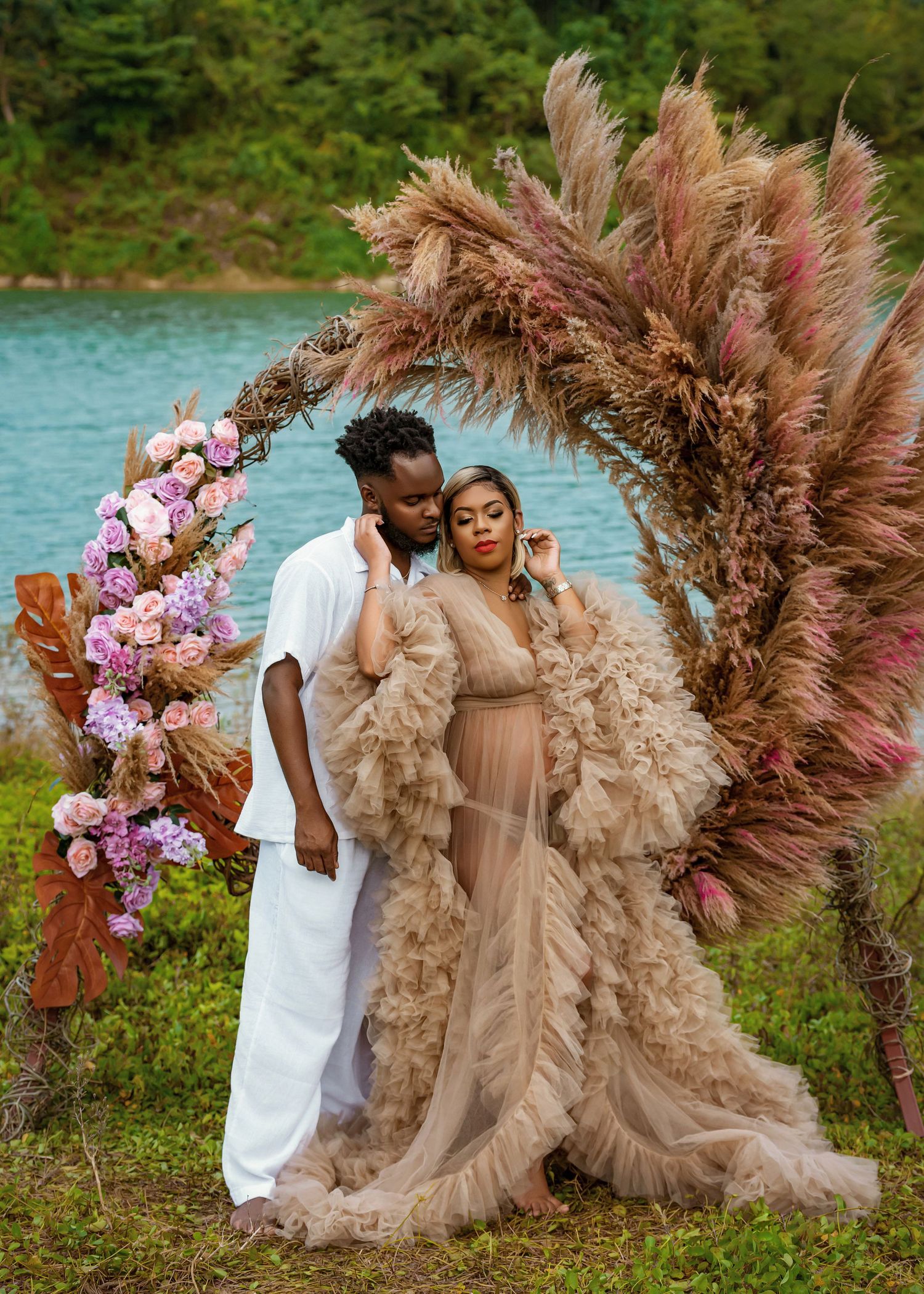 Romantic photoshoot featuring elegant floral arrangements and flowing beige dress by a waterfront.