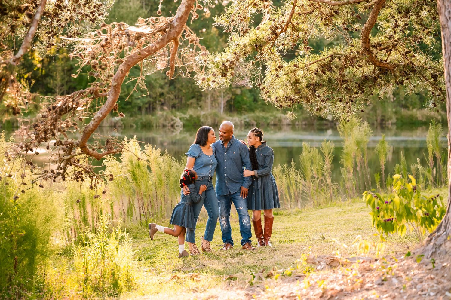 Family walking together on autumn path with golden leaves overhead.