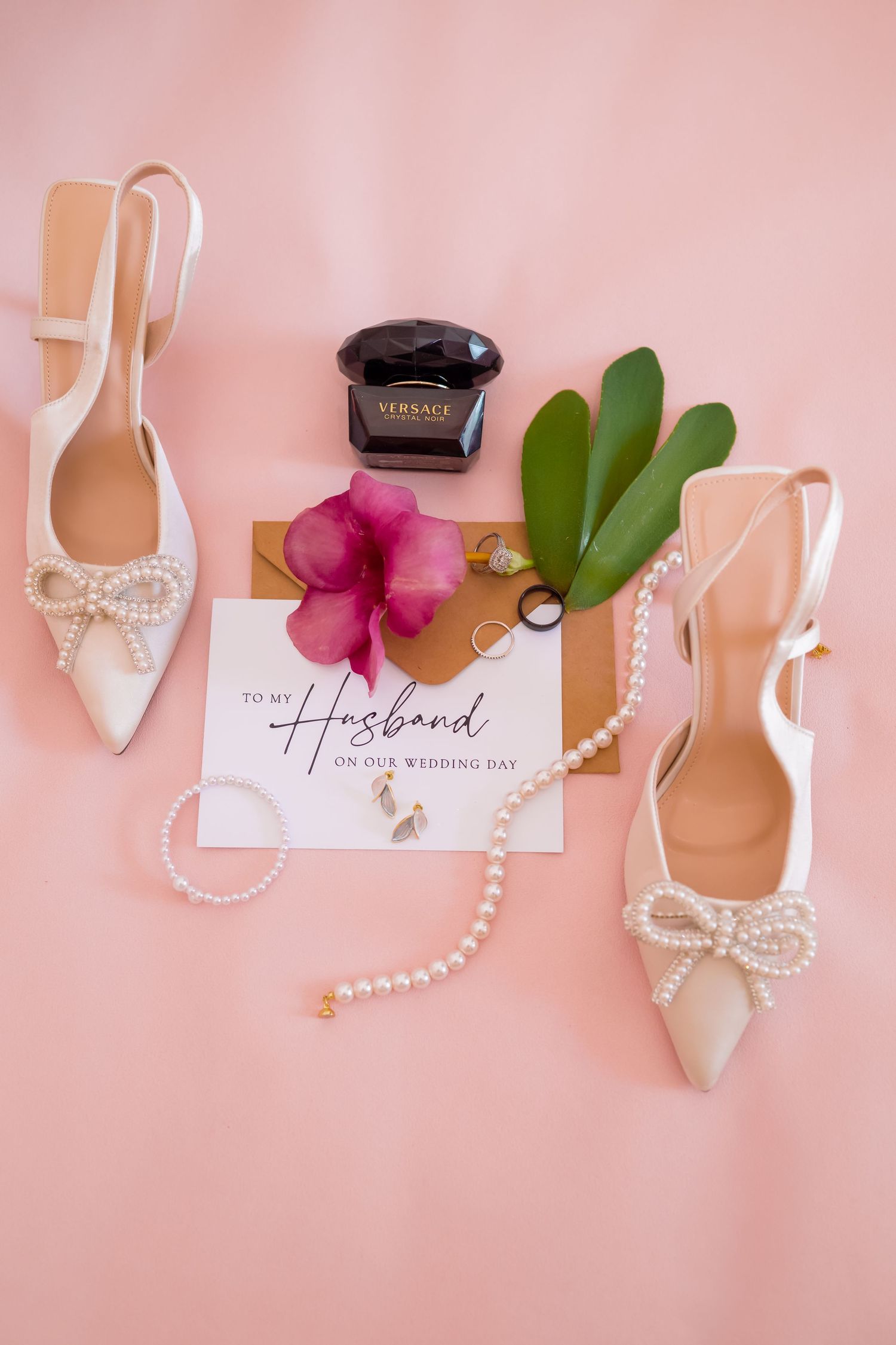 Wedding day details featuring white heels, pearl necklace, and a 'To My Husband' note on pink background.