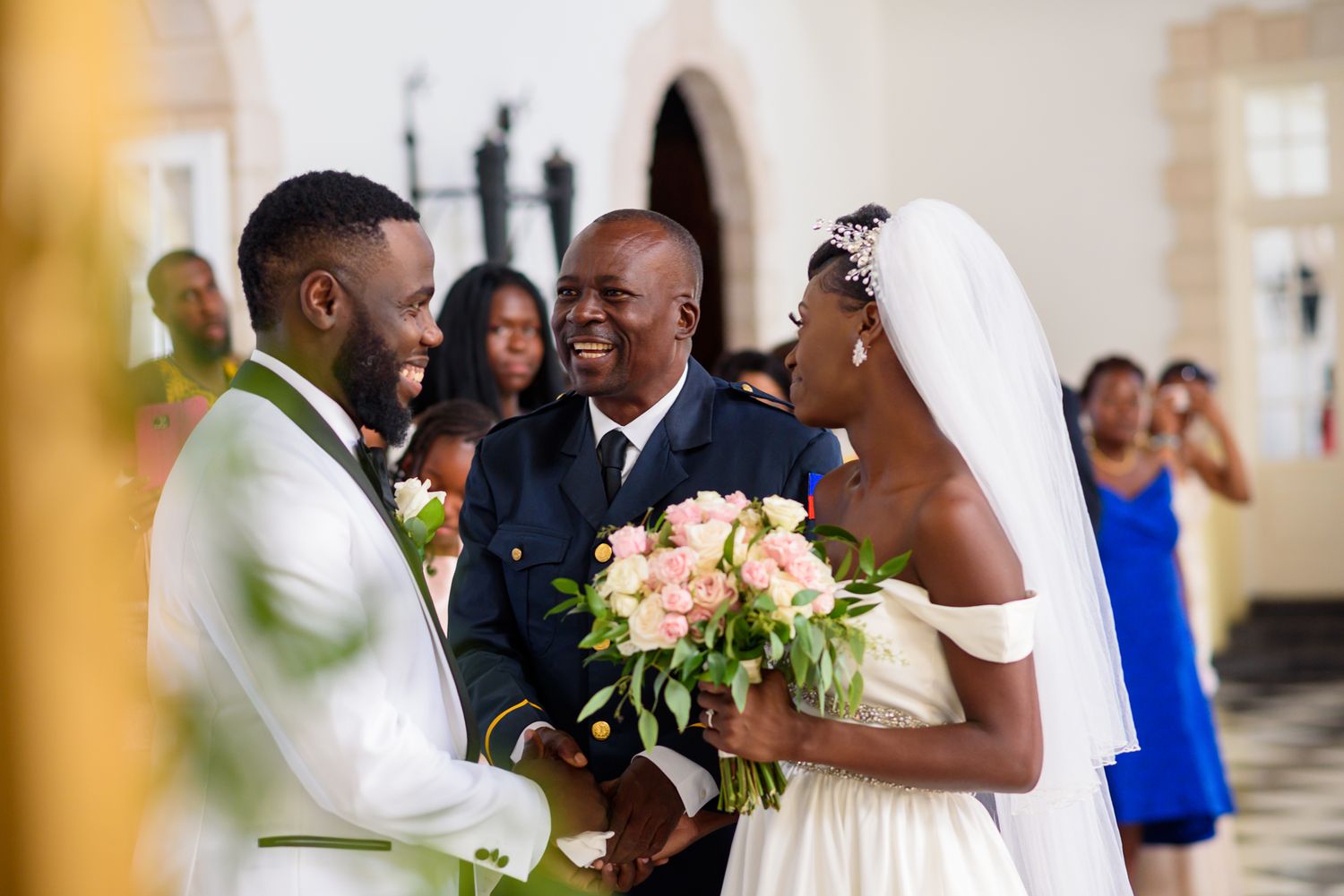 Wedding couple and guests share joyful moments during an elegant indoor ceremony.
