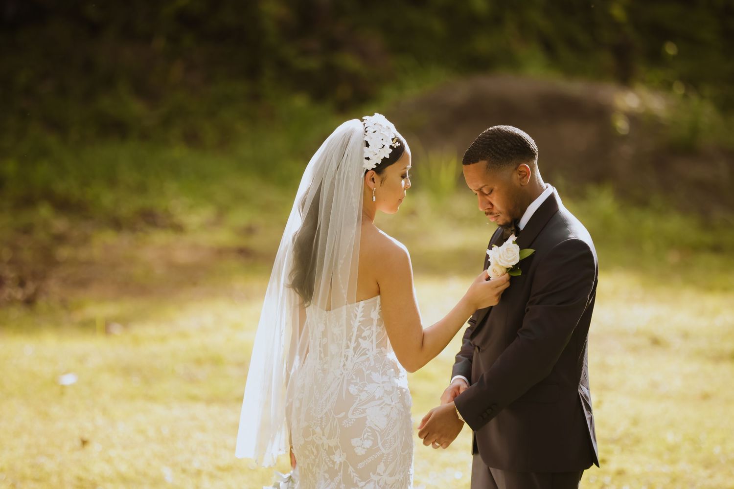 Wedding couple shares a romantic moment in golden hour lighting outdoors.