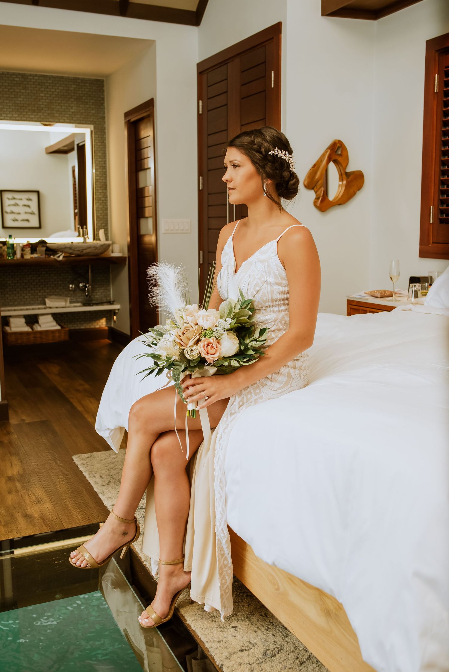 Artistic wedding photos showing details of a white dress and bouquet in a rustic room.