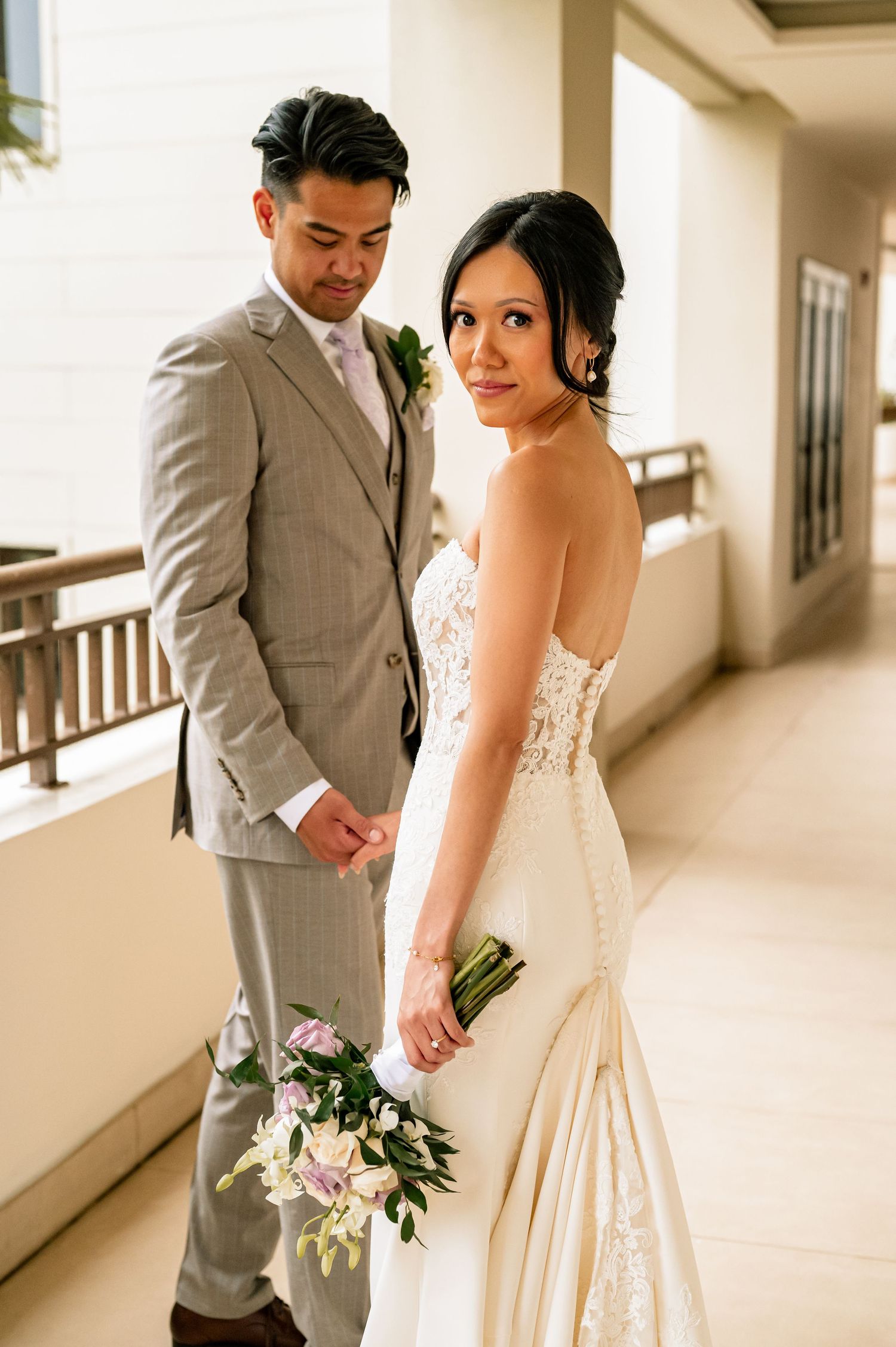 A couple shares an intimate moment in a hallway during their wedding day photoshoot.