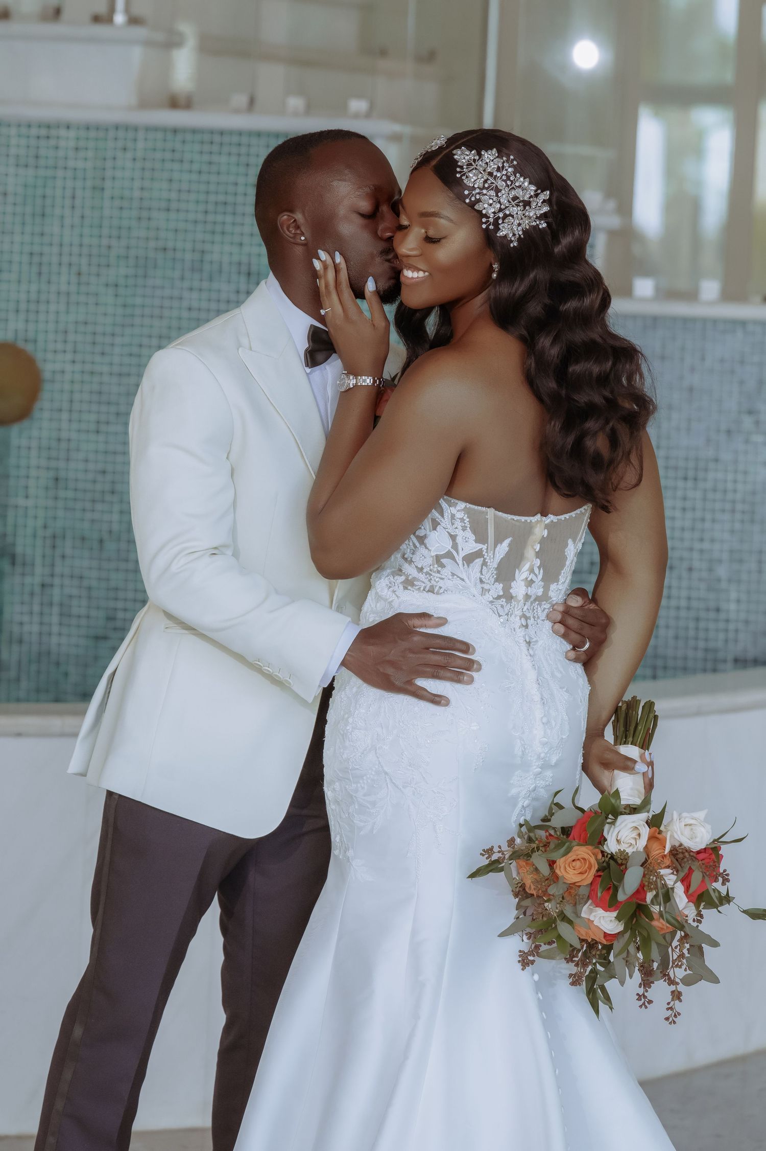 A romantic moment between newlyweds in white attire against a modern interior backdrop. Iberostar Montego Bay wedding