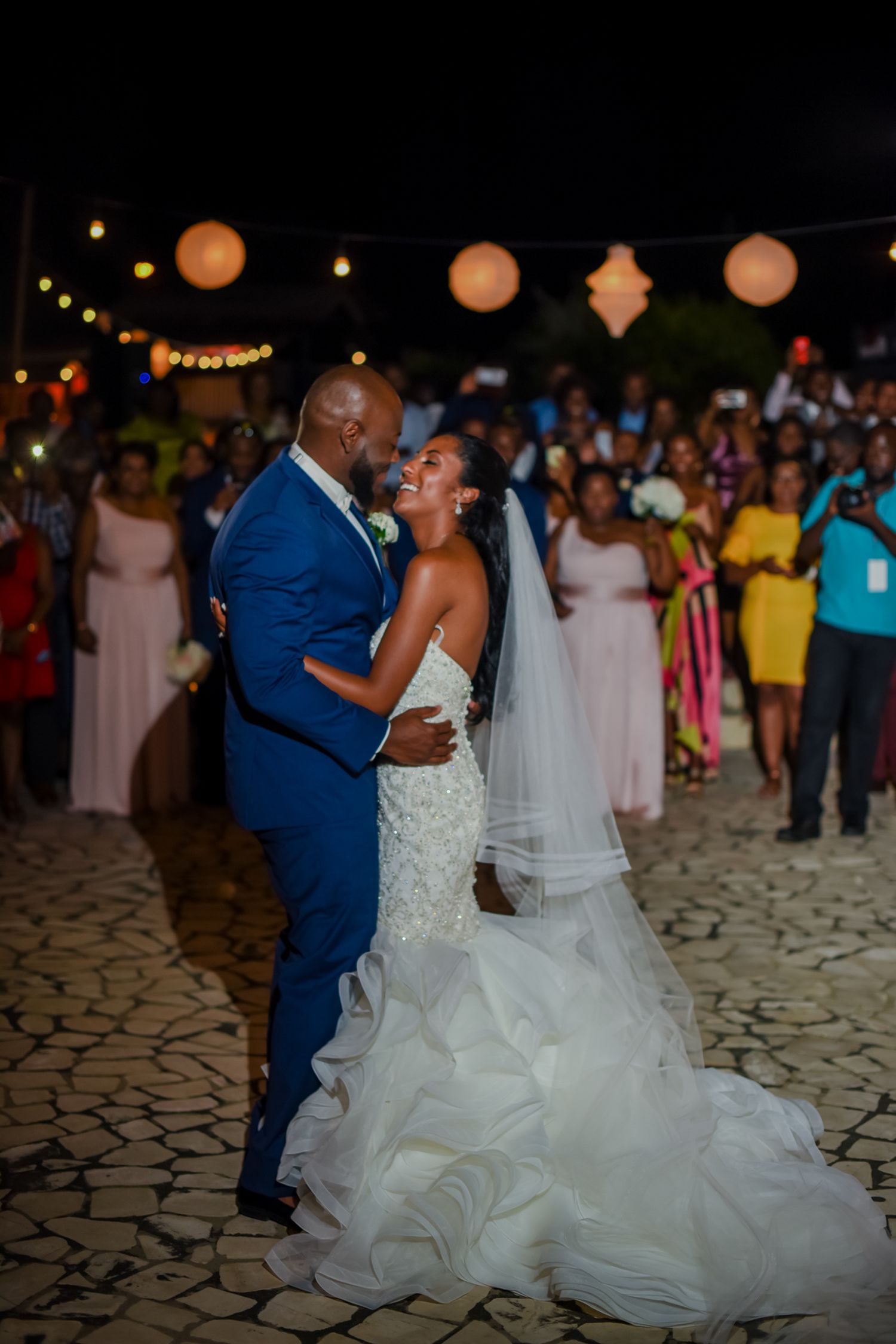 Couple sharing their first dance at an outdoor evening wedding reception.