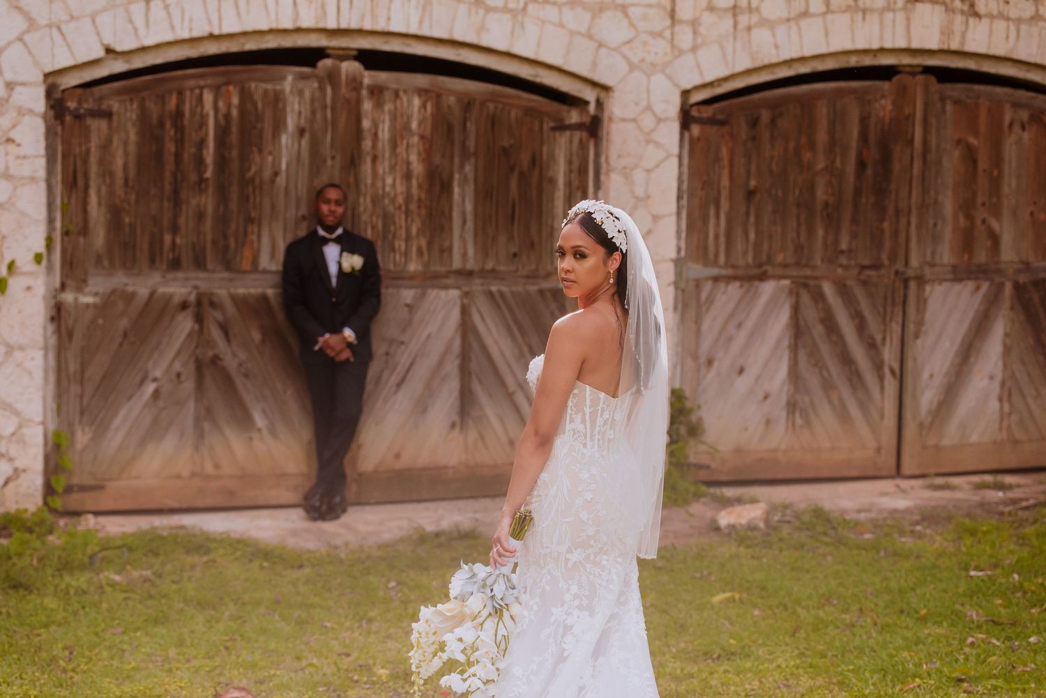 Wedding portrait featuring rustic wooden doors and stone architecture.