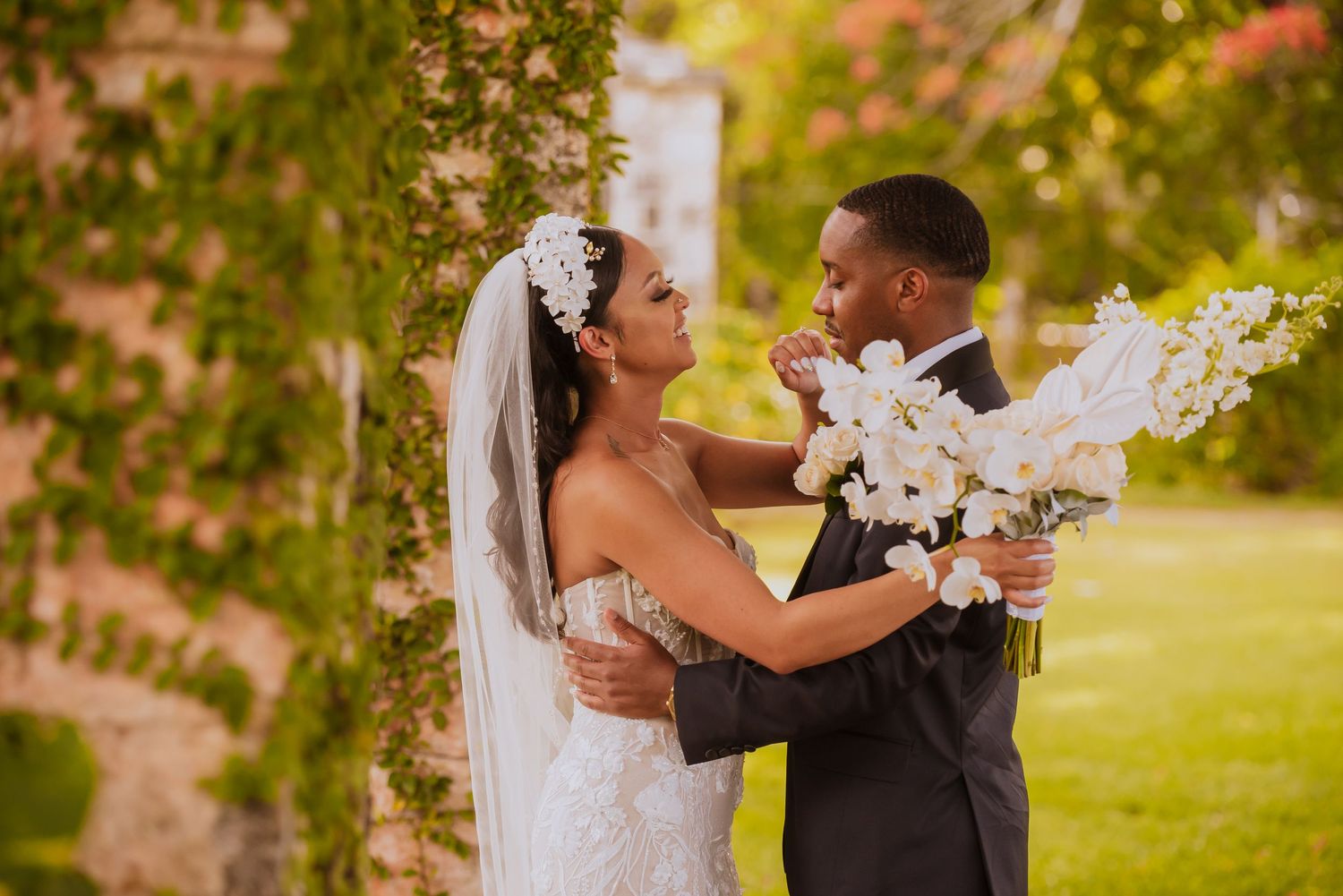 Couple sharing joyful embrace during outdoor wedding first look sequence.