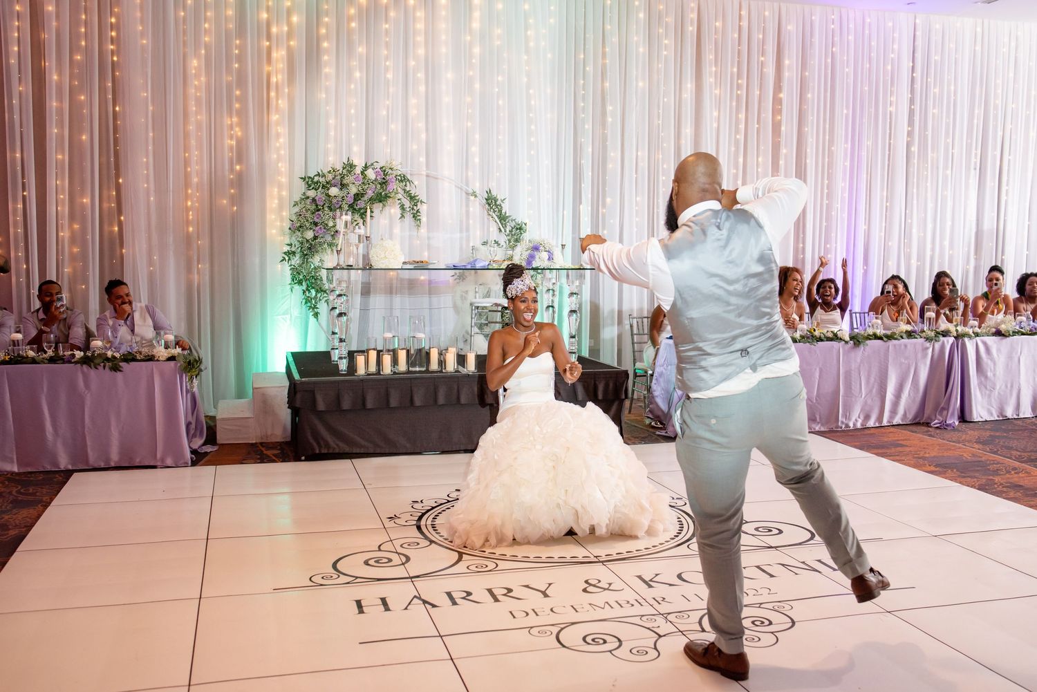 Dynamic dance moment captured on personalized wedding reception dance floor.