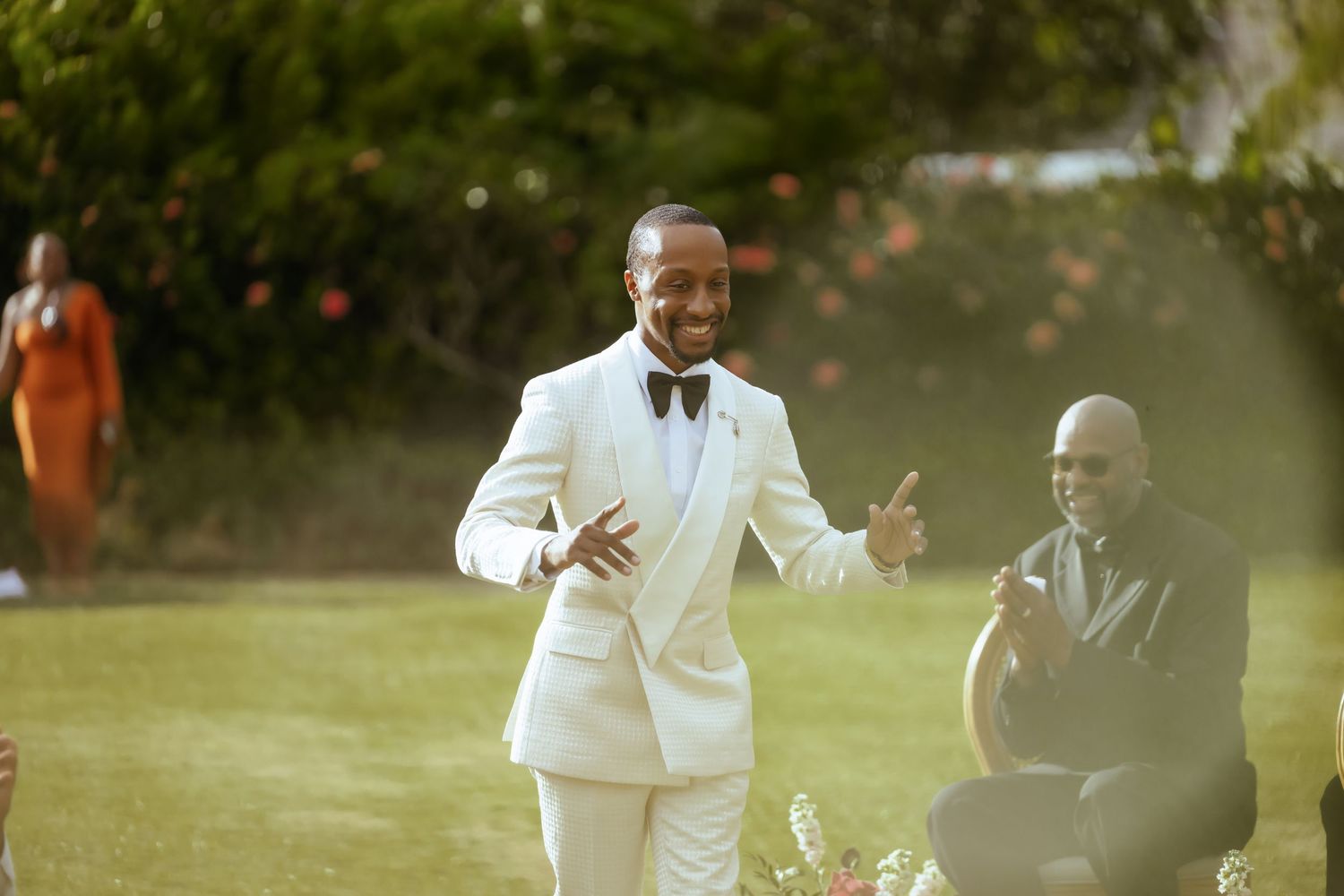 Wedding celebration taking place outdoors with guests in formal attire.