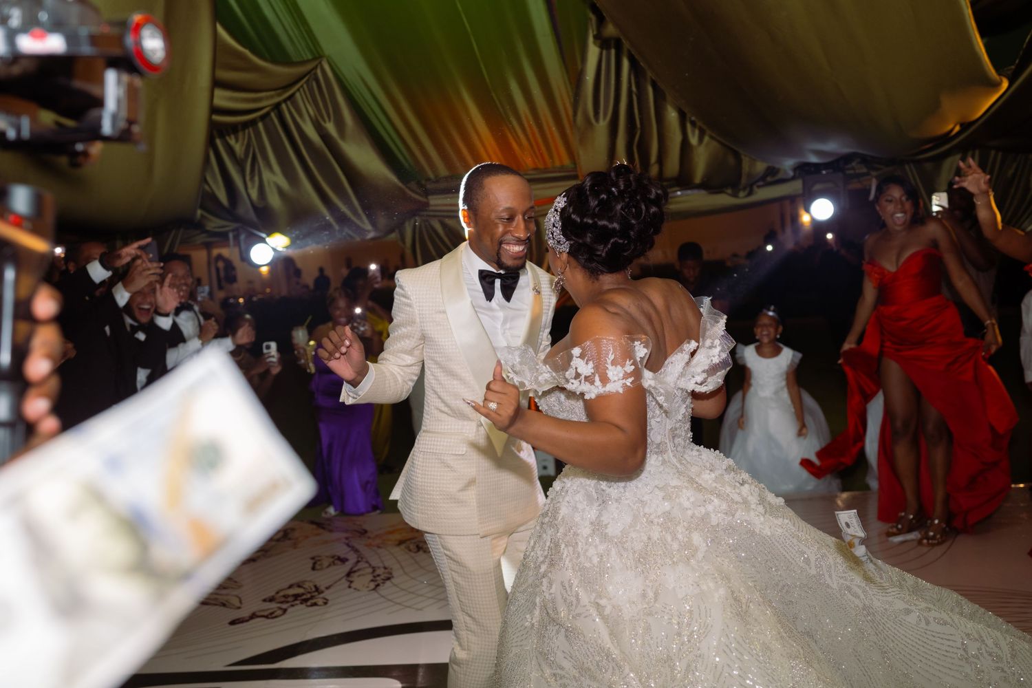 Wedding reception celebration under twinkling lights with elegant table settings and decor.