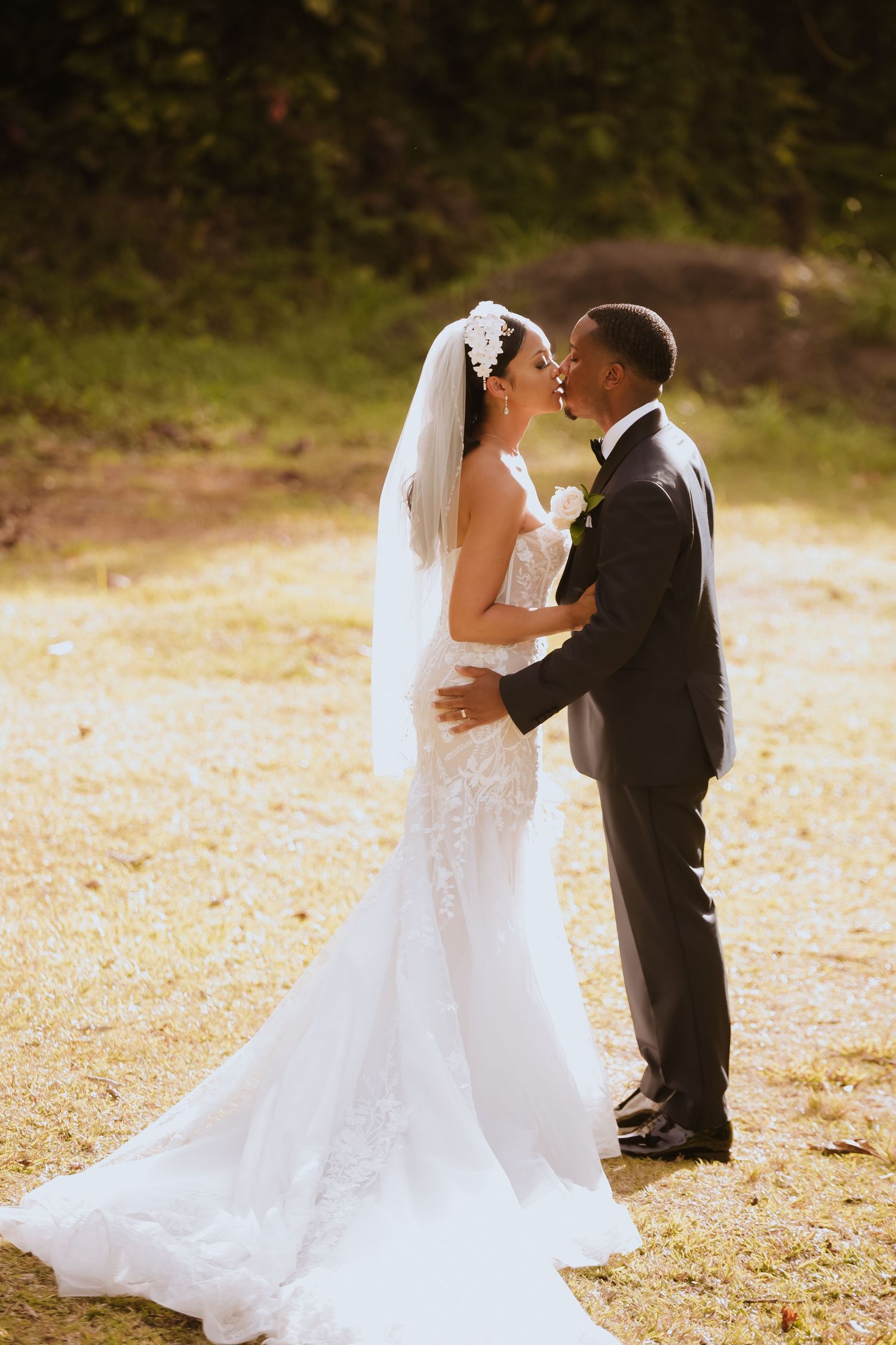 A romantic wedding portrait captured in golden sunlight with a flowing white dress.