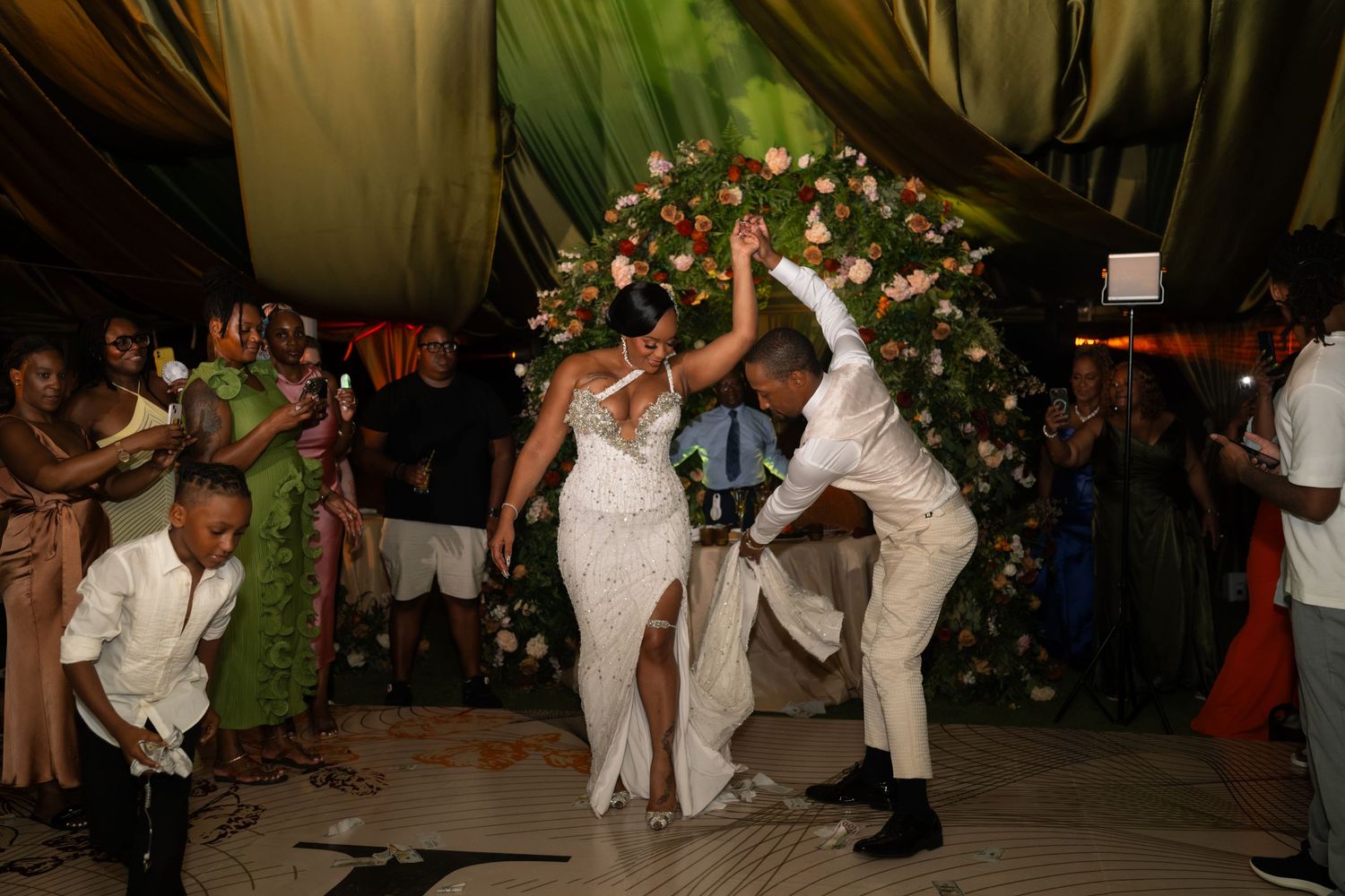Wedding reception dance party with guests celebrating on dance floor with festive lighting.