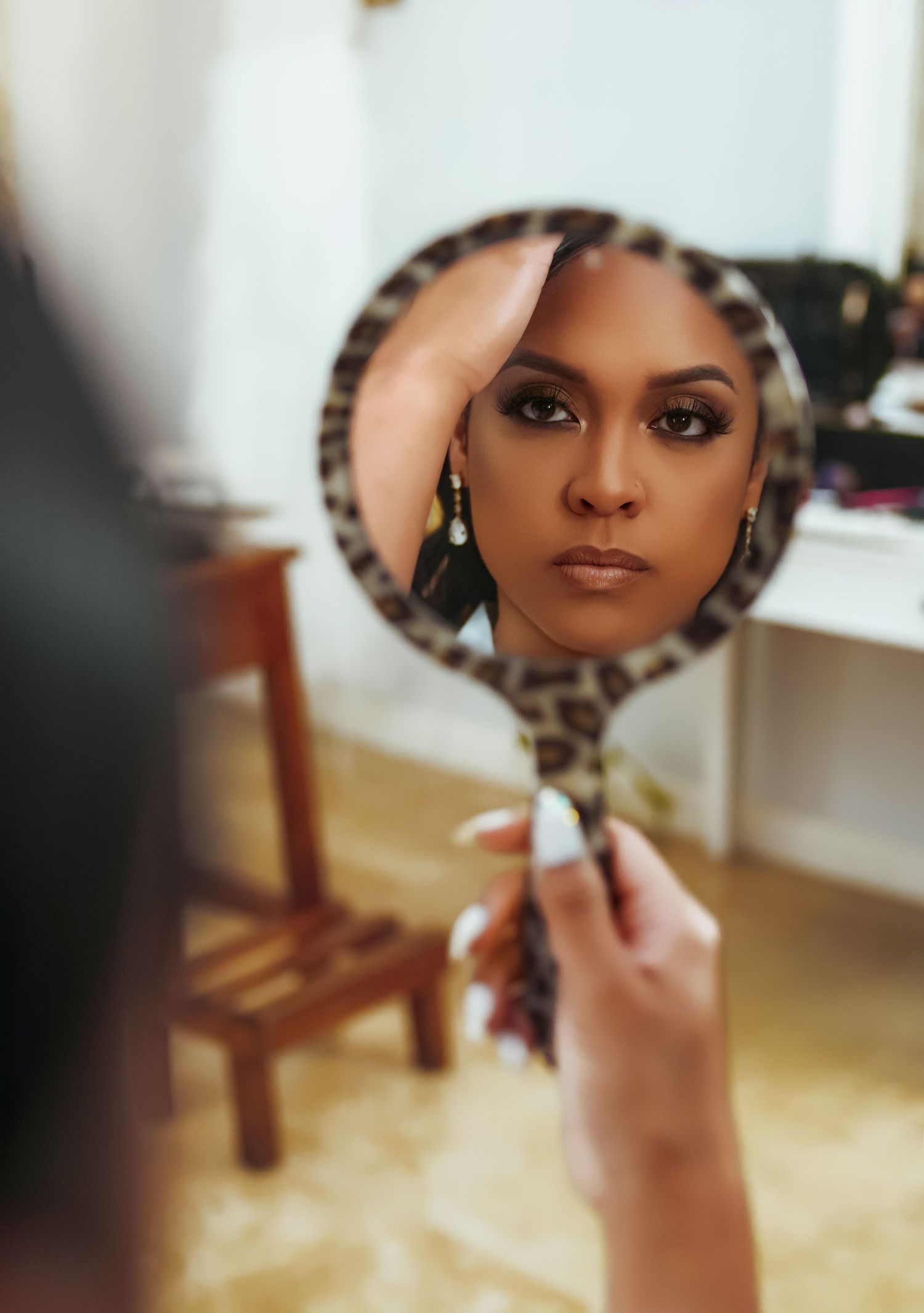 An artistic reflection of bridal makeup captured in a leopard print handheld mirror.