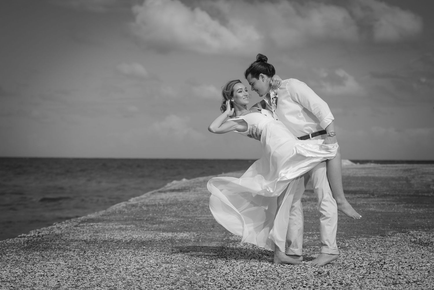 Black and white beach wedding photos capturing movement and romance.